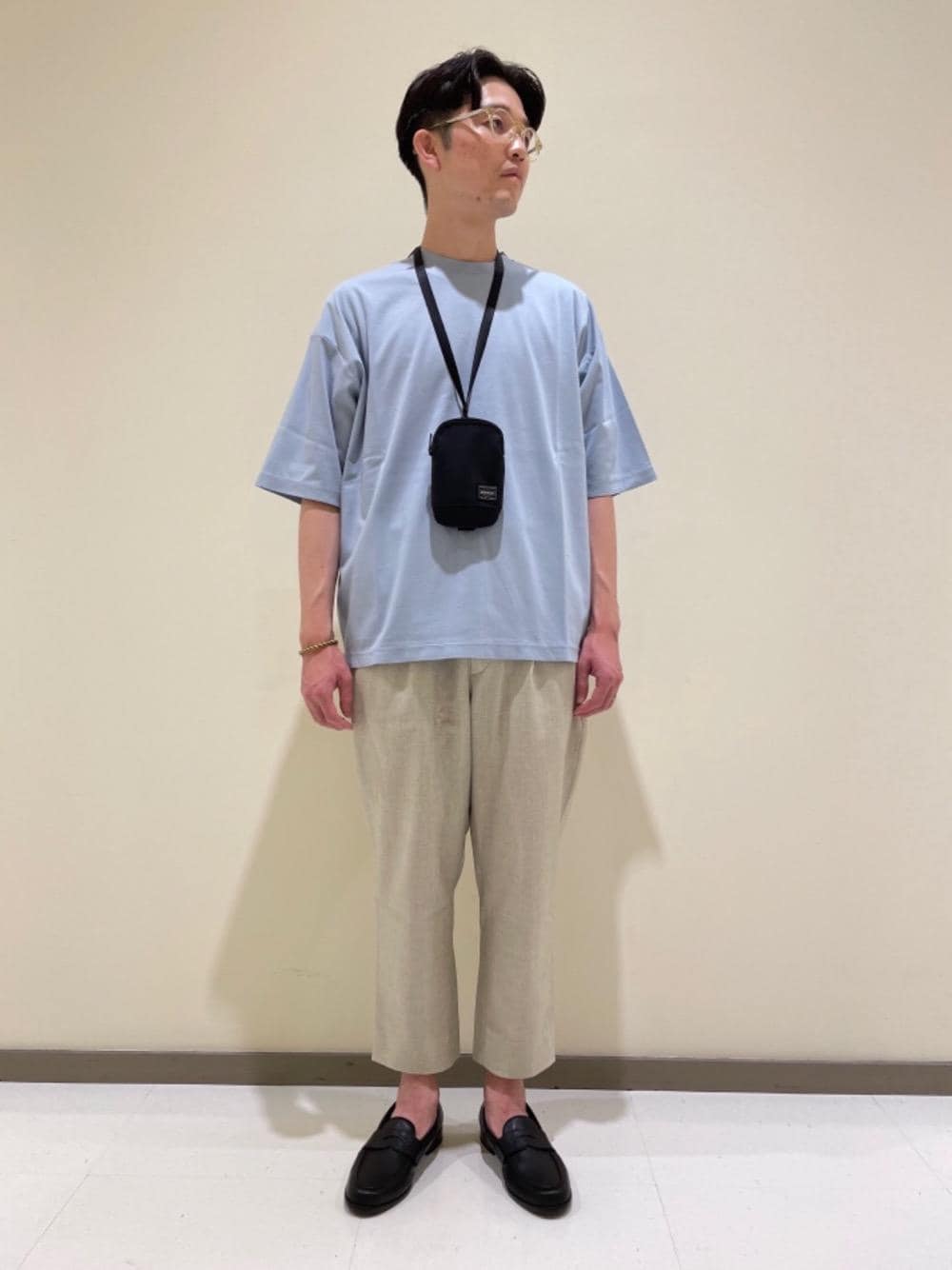 ブラック系のショルダーバッグ、ブラック系のローファー、ブルー系のTシャツ/カットソーを着用したメンズの夏コーディネートの1枚目の写真