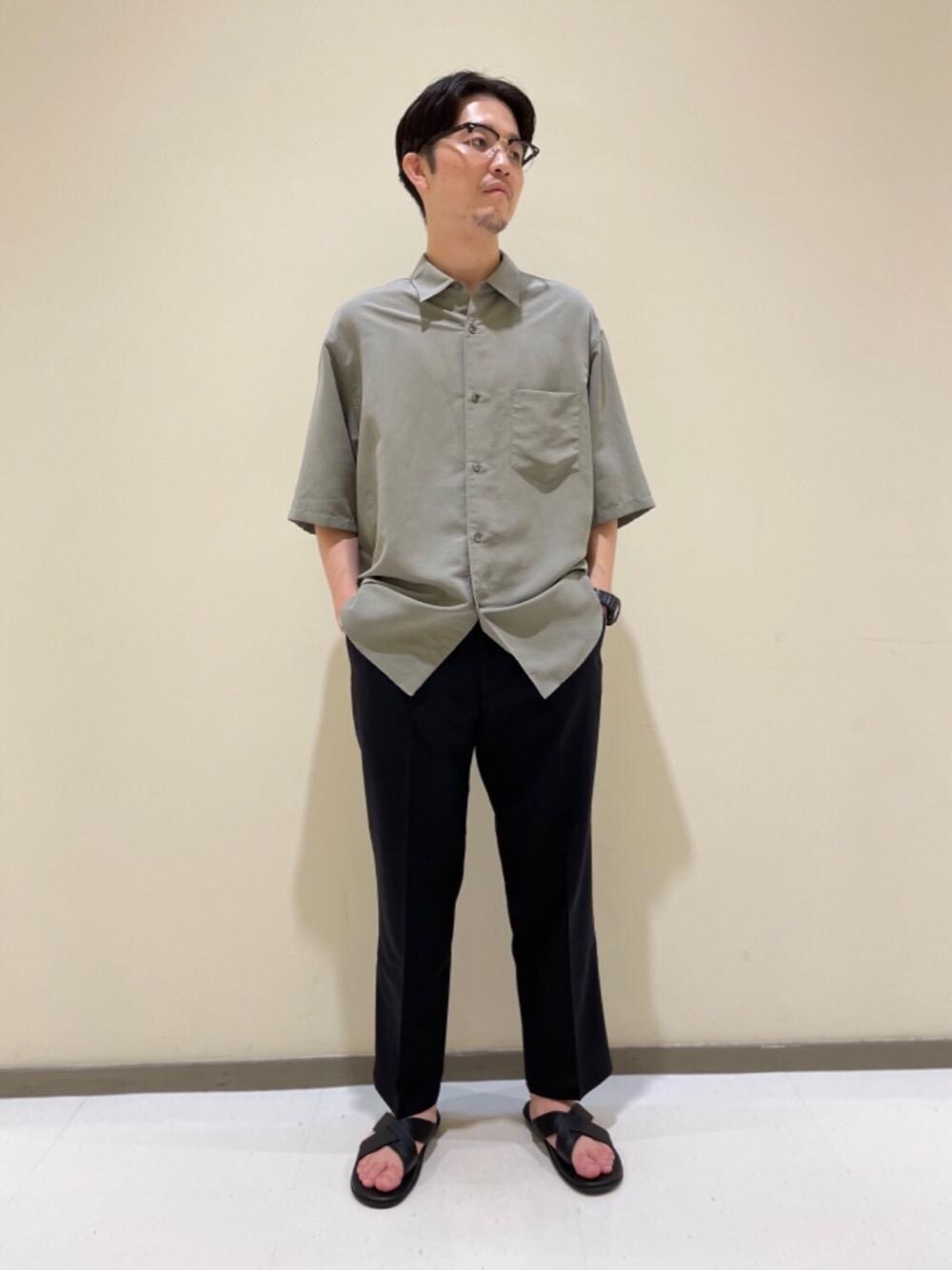 ブルー系のスラックス、ブラック系のサンダル、グリーン系のシャツ/ブラウスを着用したメンズの夏コーディネートの1枚目の写真