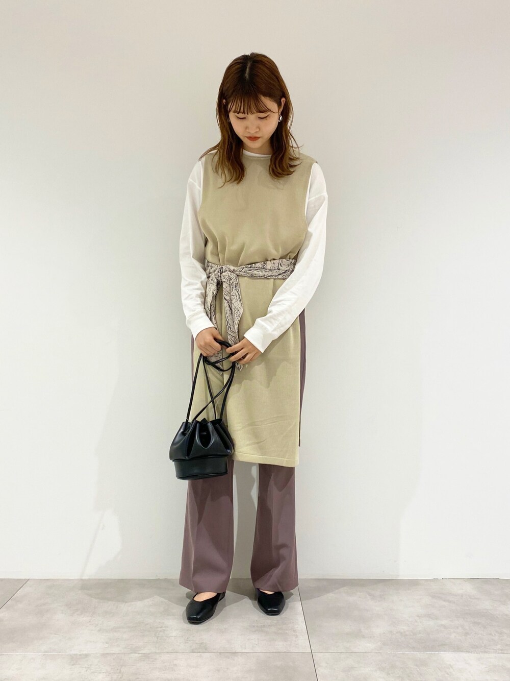 ホワイト系のTシャツ/カットソー、ベージュ系のベスト、ブラック系のショルダーバッグを着用したレディースの秋コーディネートの1枚目の写真