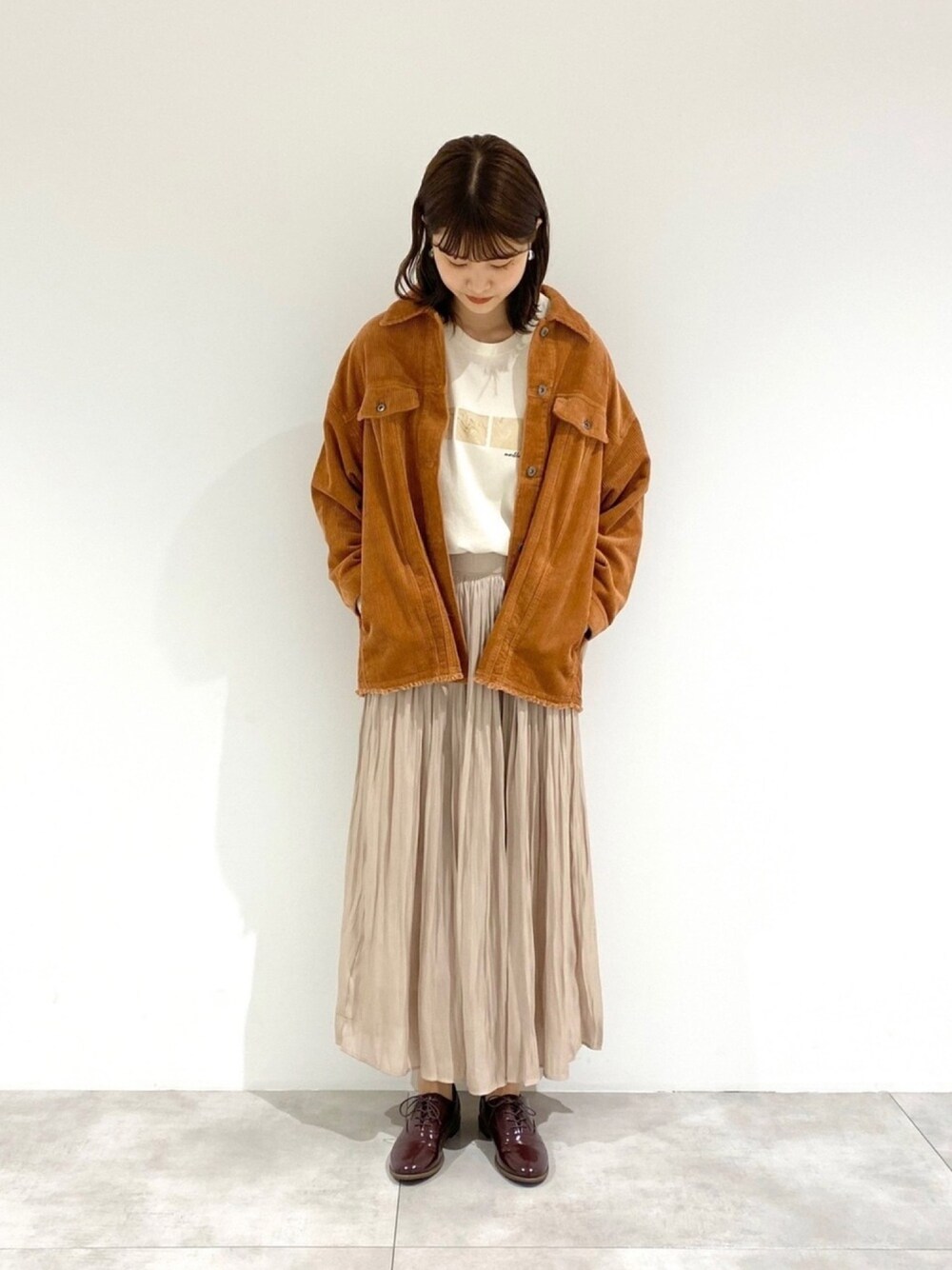 オレンジ系のその他アウター、その他のTシャツ/カットソー、ベージュ系のスカートを着用したレディースの秋コーディネートの1枚目の写真