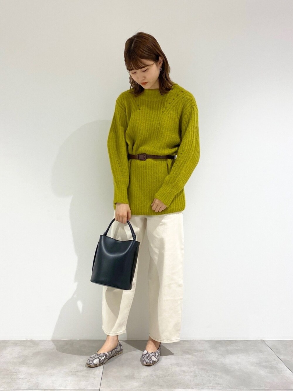 グリーン系のニット/セーター、ホワイト系のその他パンツ、ブラック系のショルダーバッグを着用したレディースの秋コーディネートの1枚目の写真