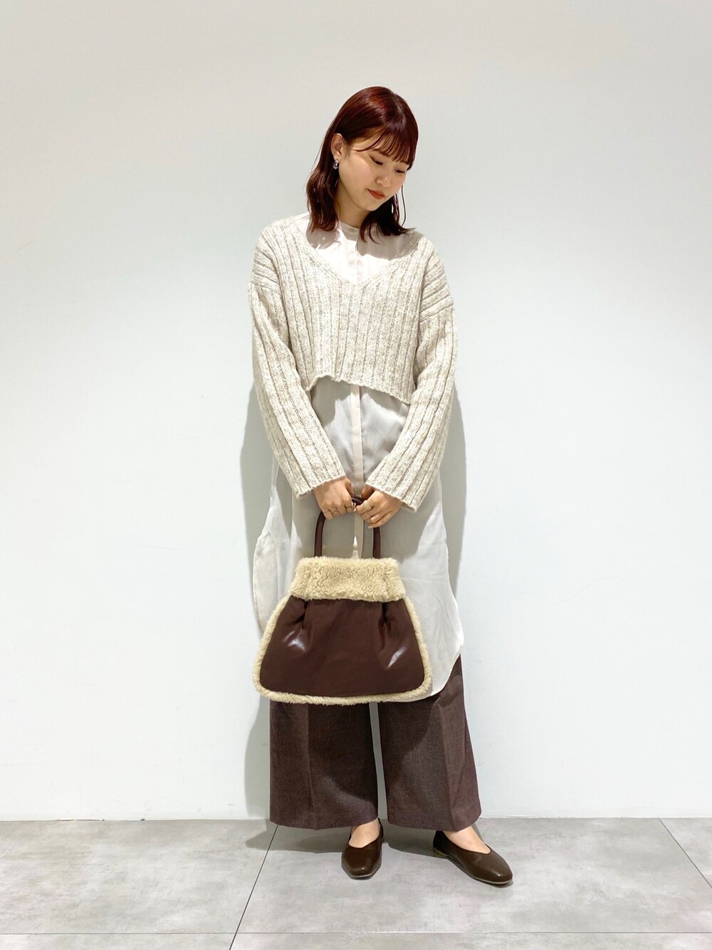 ベージュ系のニット/セーター、ホワイト系のシャツ/ブラウス、ブラウン系のその他パンツを着用したレディースの秋コーディネートの1枚目の写真