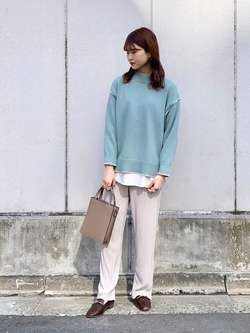 グリーン系のニット/セーター、ベージュ系のその他パンツ、ホワイト系のシャツ/ブラウスを着用したレディースの春コーディネートの1枚目の写真