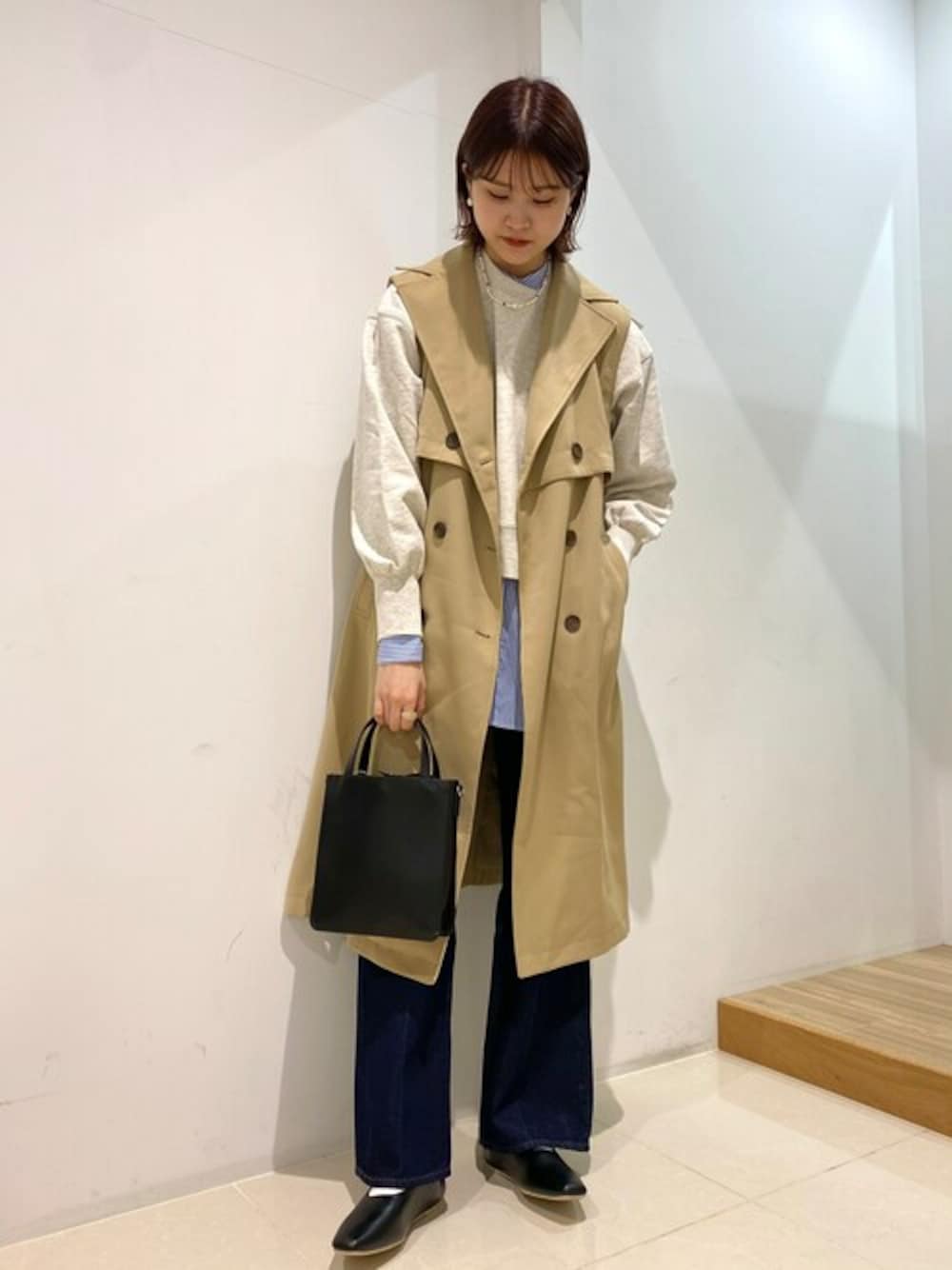 ベージュ系のトレンチコート、ブルー系のシャツ/ブラウス、ブルー系のデニムパンツを着用したレディースの冬コーディネートの1枚目の写真