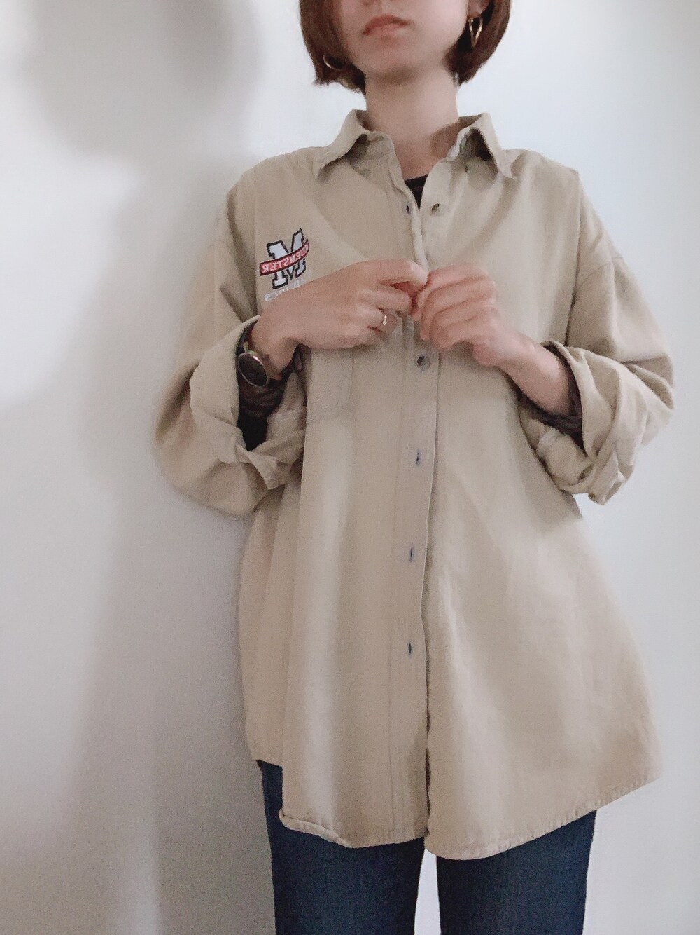 ベージュ系のシャツ/ブラウス、ブルー系のデニムパンツ、ゴールド系のピアス（両耳用）を着用したレディースの春コーディネートの1枚目の写真