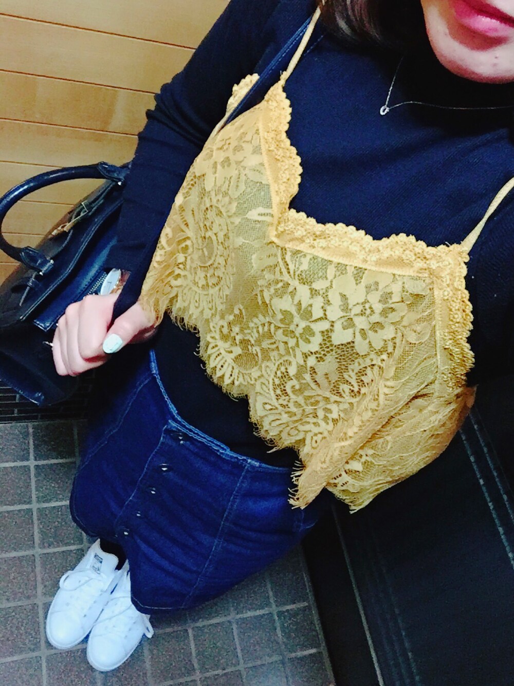 ホワイト系のスニーカー、ブルー系のデニムスカート、ブラック系のトップスを着用したレディースの春コーディネートの1枚目の写真