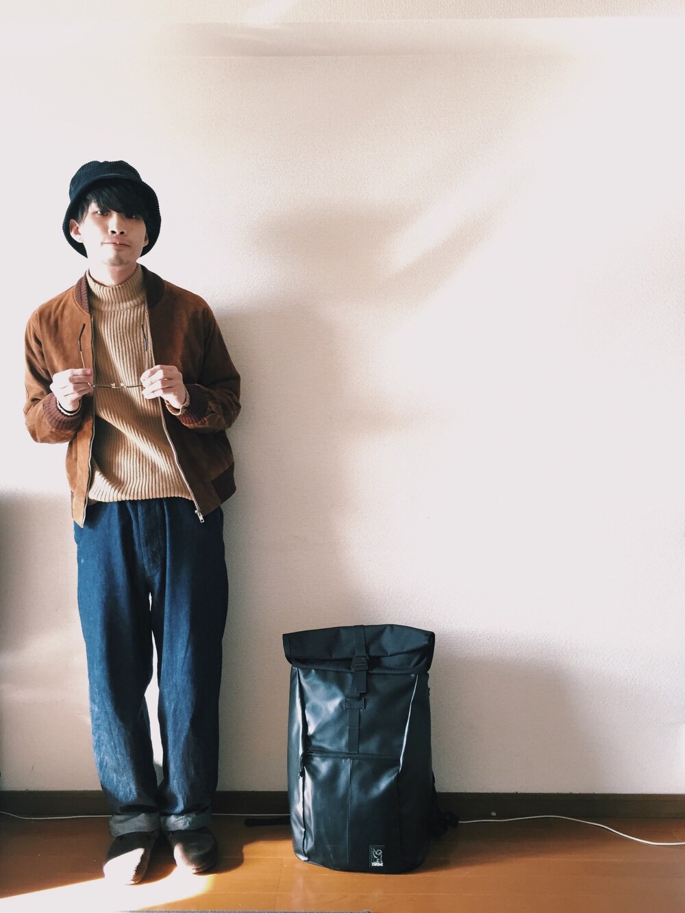 ブルー系のデニムパンツ、ベージュ系のニット/セーター、ブラウン系のブルゾンを着用したメンズの冬コーディネートの1枚目の写真