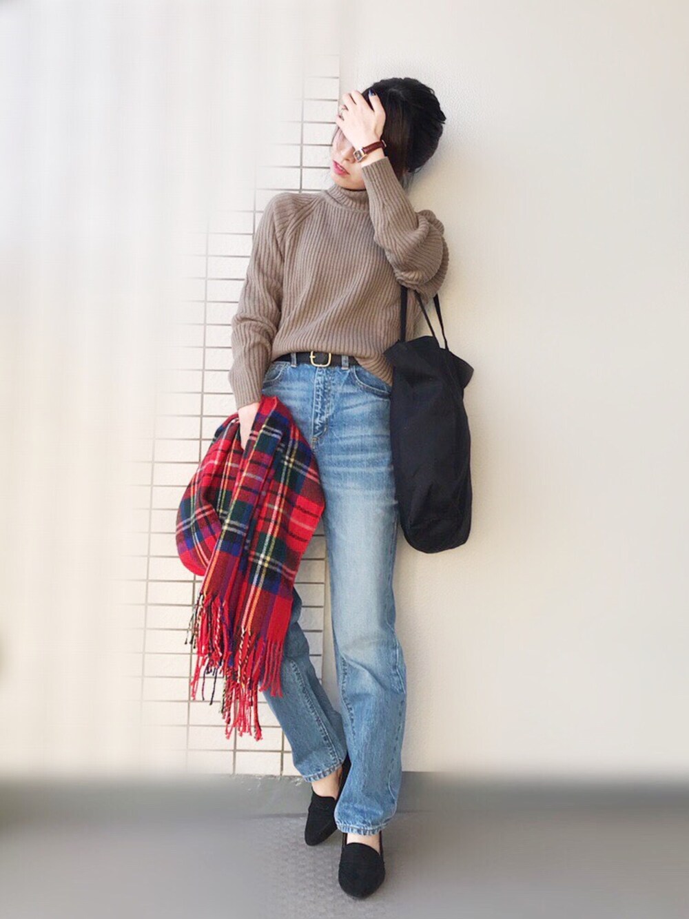 ブラウン系のニット/セーター、ブルー系のデニムパンツ、ブラック系のトートバッグを着用したレディースの冬コーディネートの1枚目の写真