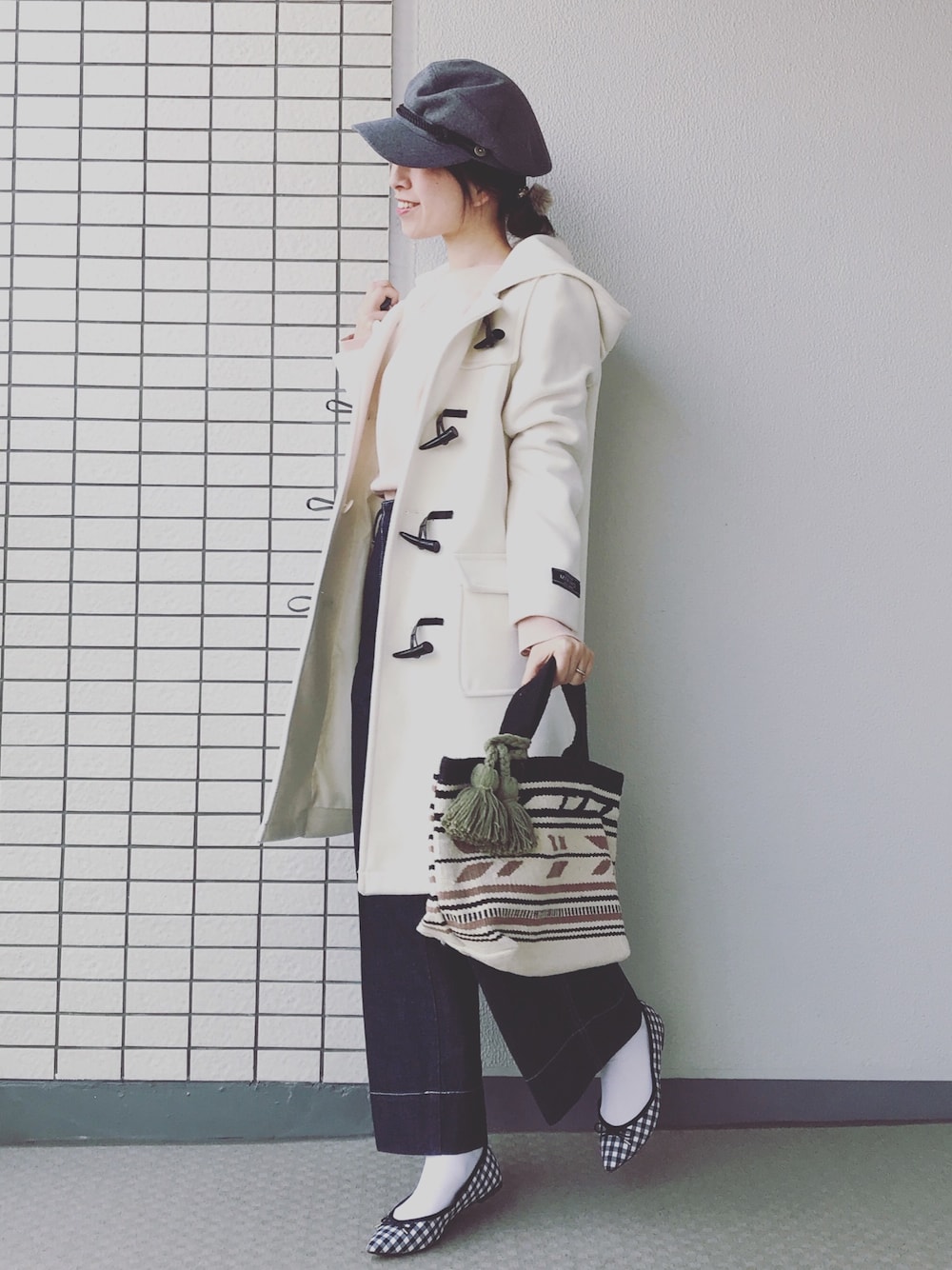 ホワイト系のダッフルコート、ピンク系のニット/セーター、ブルー系のデニムパンツを着用したレディースの冬コーディネートの1枚目の写真