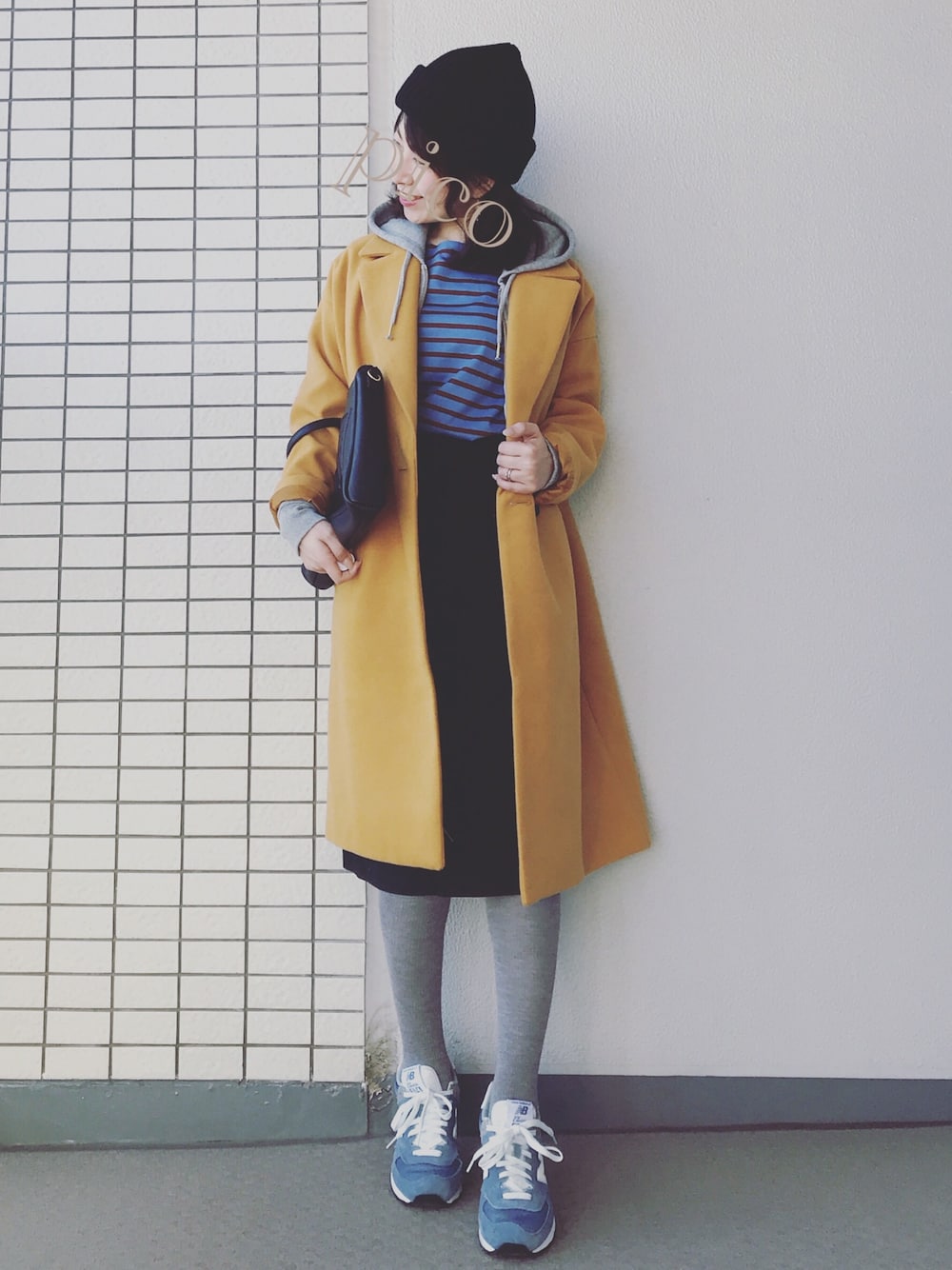 イエロー系のチェスターコート、グレー系のパーカー、ブルー系のTシャツ/カットソーを着用したレディースの冬コーディネートの1枚目の写真