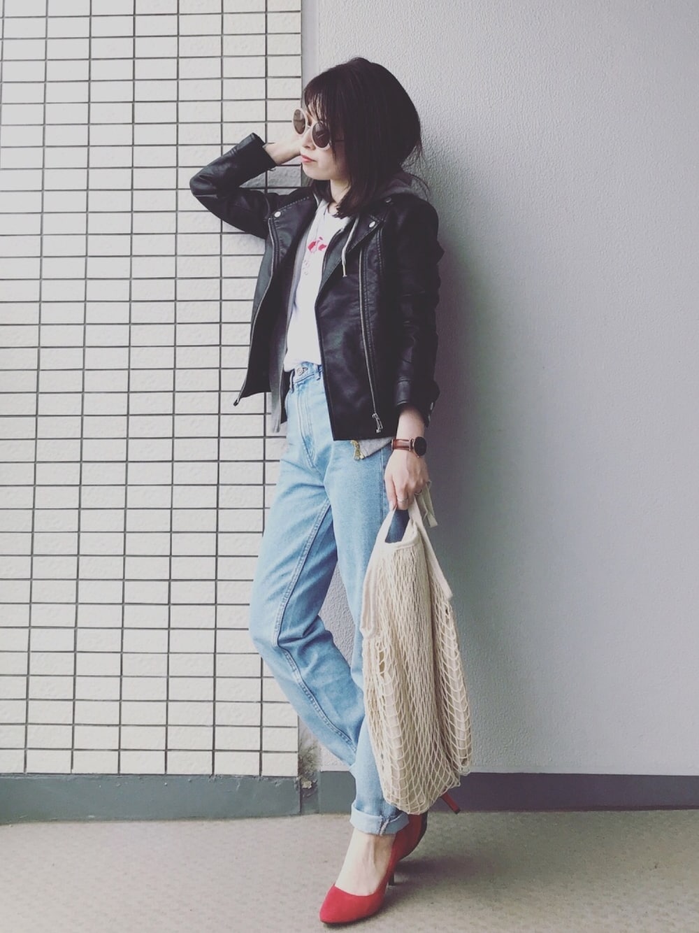 ブラック系のライダースジャケット、グレー系のパーカー、ホワイト系のTシャツ/カットソーを着用したレディースの春コーディネートの1枚目の写真