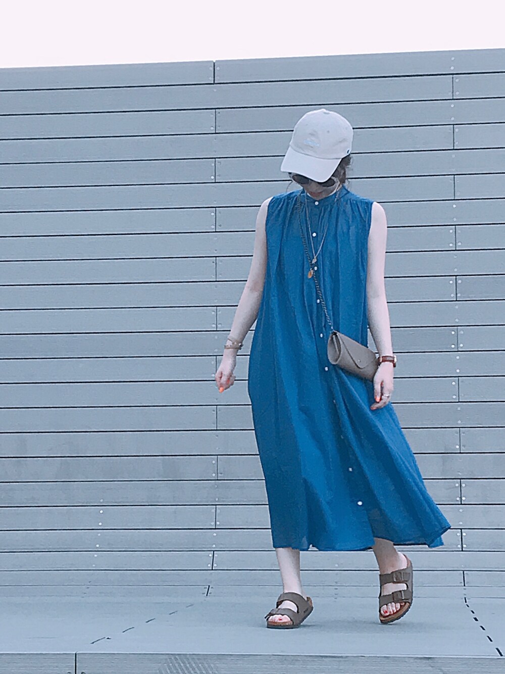 ブルー系のワンピース、ベージュ系のボディバッグ/ウエストポーチ、ブラウン系のサンダルを着用したレディースの夏コーディネートの1枚目の写真