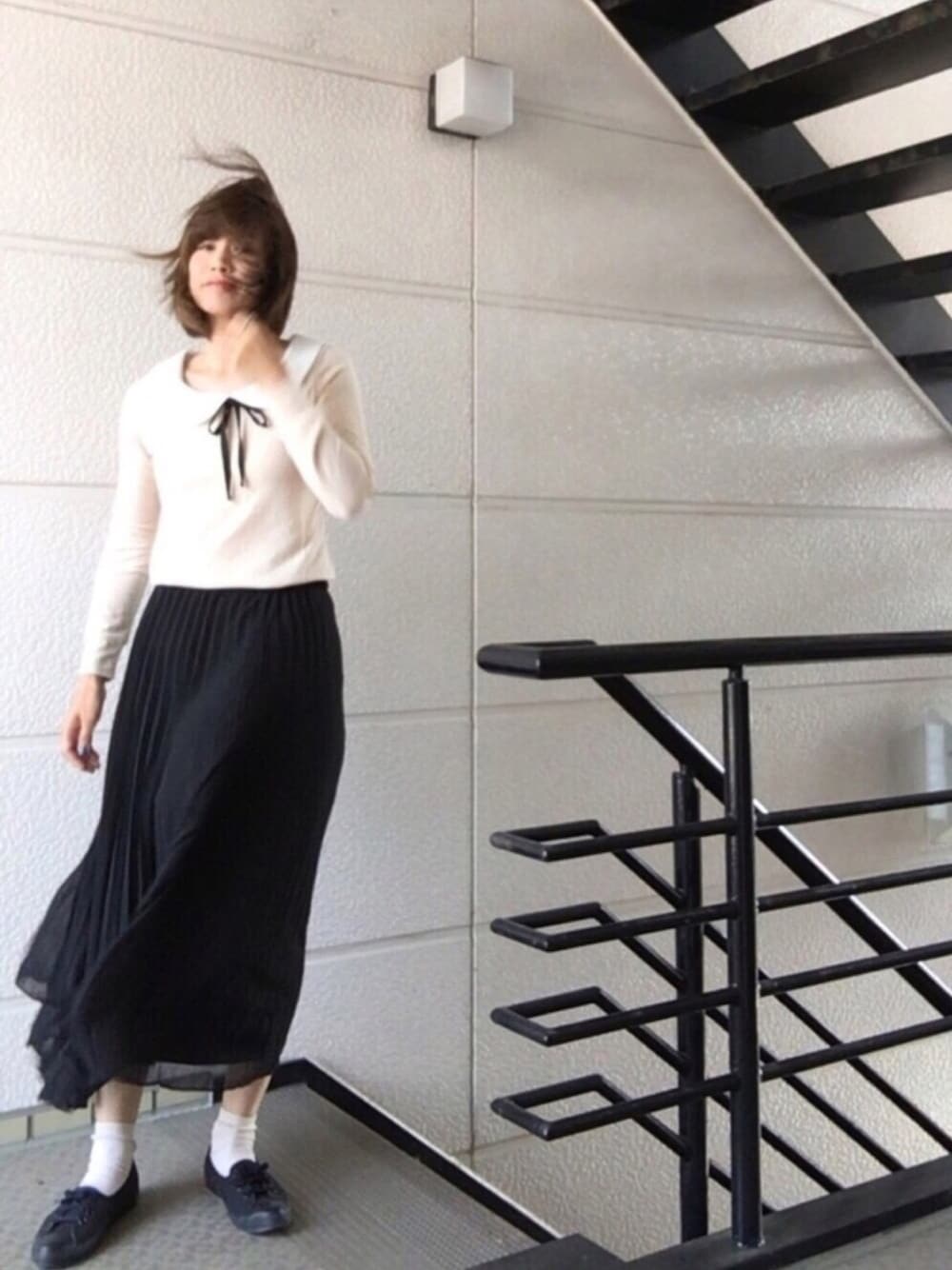ブラック系のスカート、ブラック系のスニーカー、ベージュ系のソックス/靴下を着用したレディースの春コーディネートの1枚目の写真