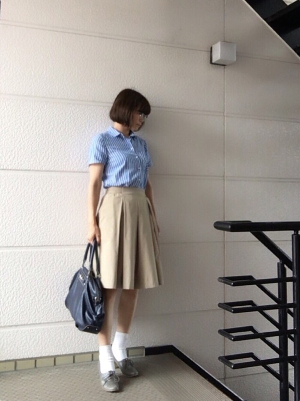 ブルー系のシャツ/ブラウス、ベージュ系のスカート、グレー系のパンプスを着用したレディースの夏コーディネートの1枚目の写真