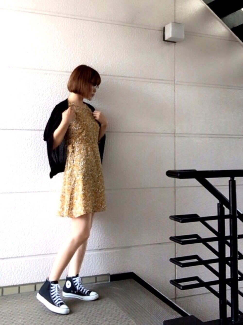 イエロー系のワンピース、ブラック系のスニーカー、ブラック系のニット/セーターを着用したレディースの夏コーディネートの1枚目の写真