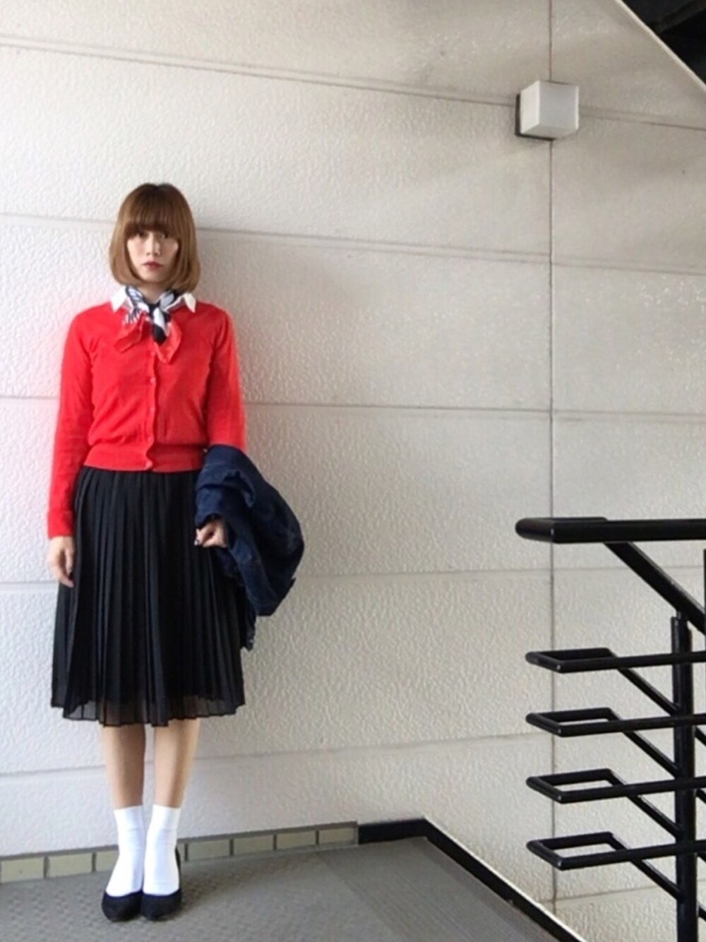 レッド系のカーディガン/ボレロ、ブルー系のデニムジャケット、ブラック系のスカートを着用したレディースの秋コーディネートの1枚目の写真