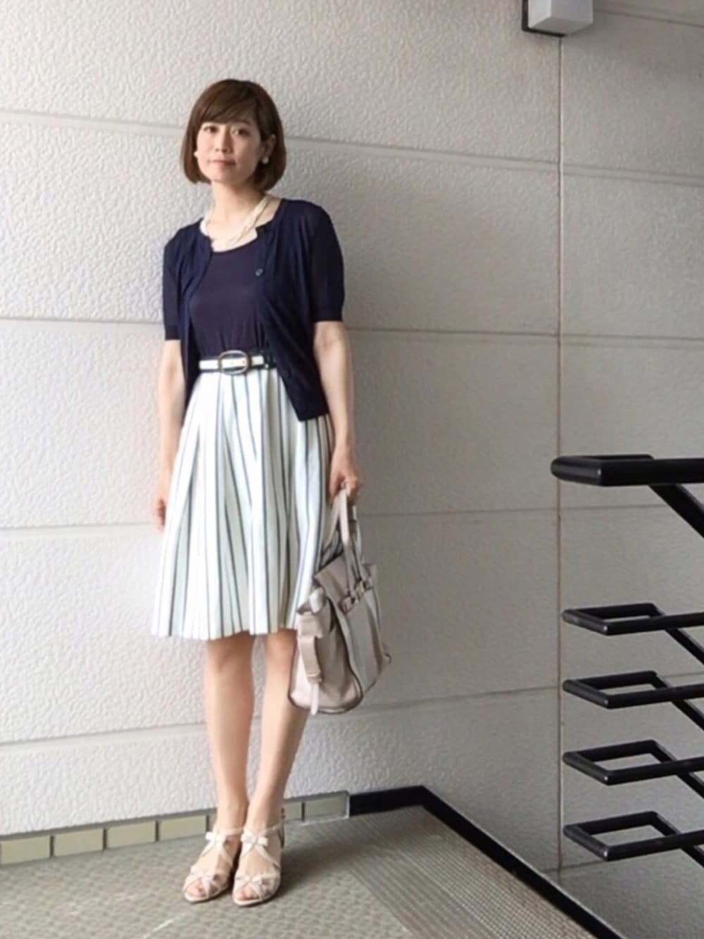 ブルー系のニット/セーター、ブルー系のワンピース/ドレス、ホワイト系のバッグを着用したレディースの春コーディネートの1枚目の写真