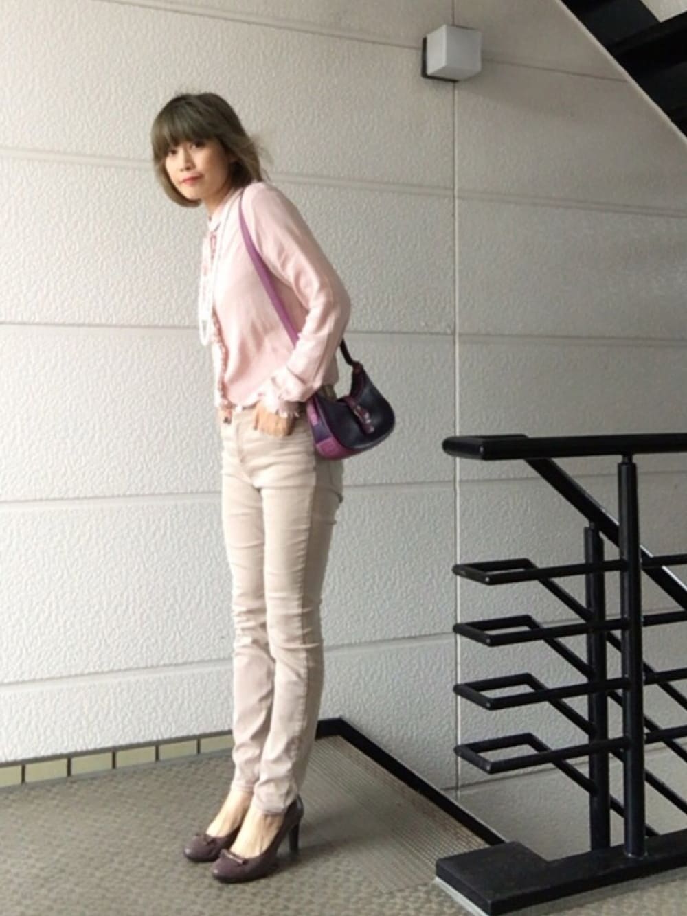 ピンク系のシャツ/ブラウス、パープル系のショルダーバッグ、ピンク系のデニムパンツを着用したレディースの秋コーディネートの1枚目の写真