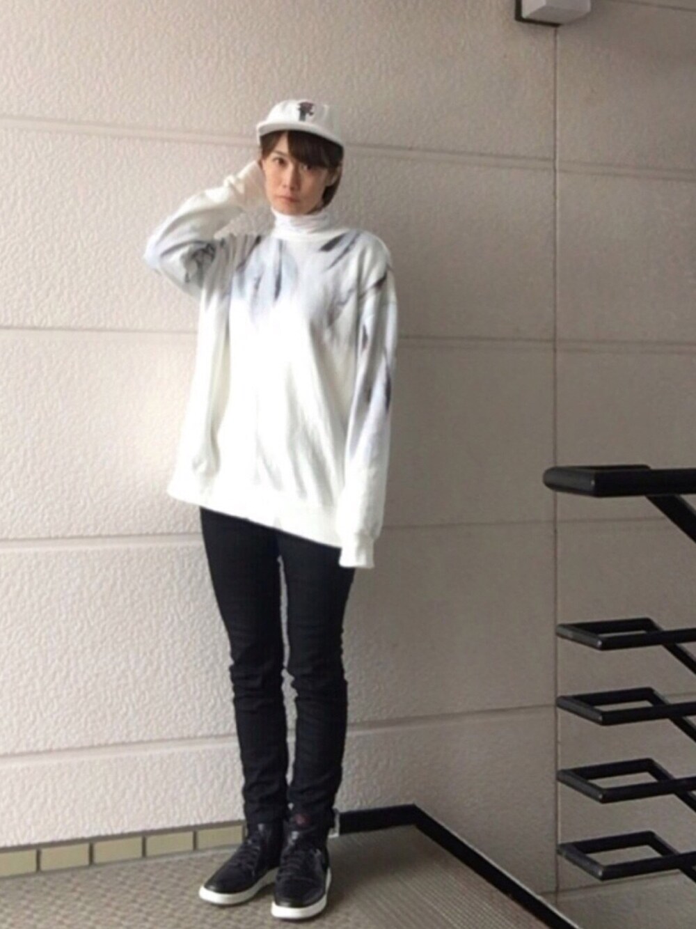 ホワイト系のスウェット、ブラック系のパンツ、ブラック系のスニーカーを着用したレディースの冬コーディネートの1枚目の写真