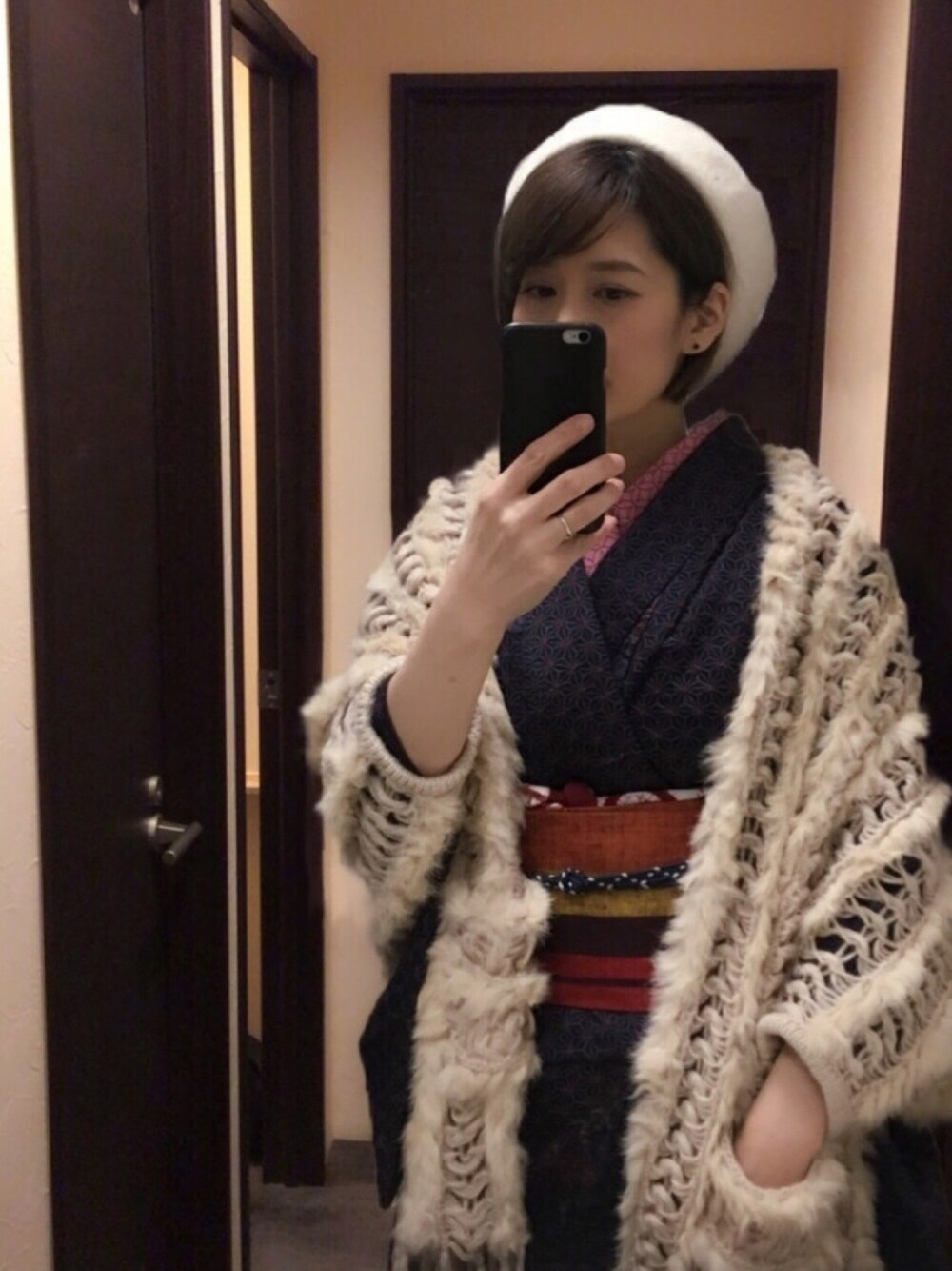 ベージュ系のブーツ、ホワイト系のハンチング/ベレー帽、シルバー系のリングを着用したレディースの冬コーディネートの1枚目の写真