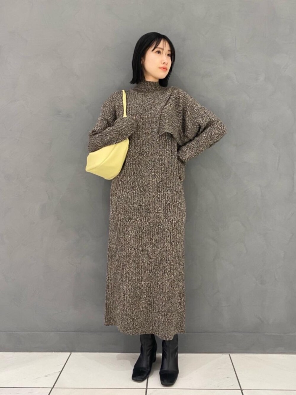 イエロー系のショルダーバッグ、ブラウン系のワンピース、パープル系のストール/ショールを着用したレディースの冬コーディネートの1枚目の写真