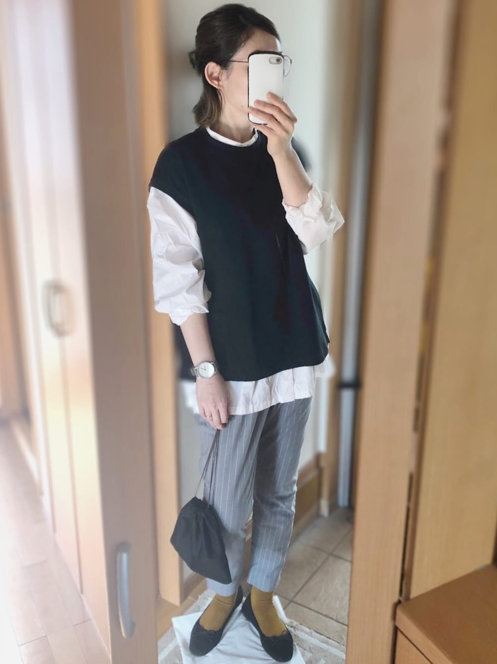 ブラック系のアンサンブル、ホワイト系のシャツ/ブラウス、グレー系のパンツを着用したレディースの秋コーディネートの1枚目の写真