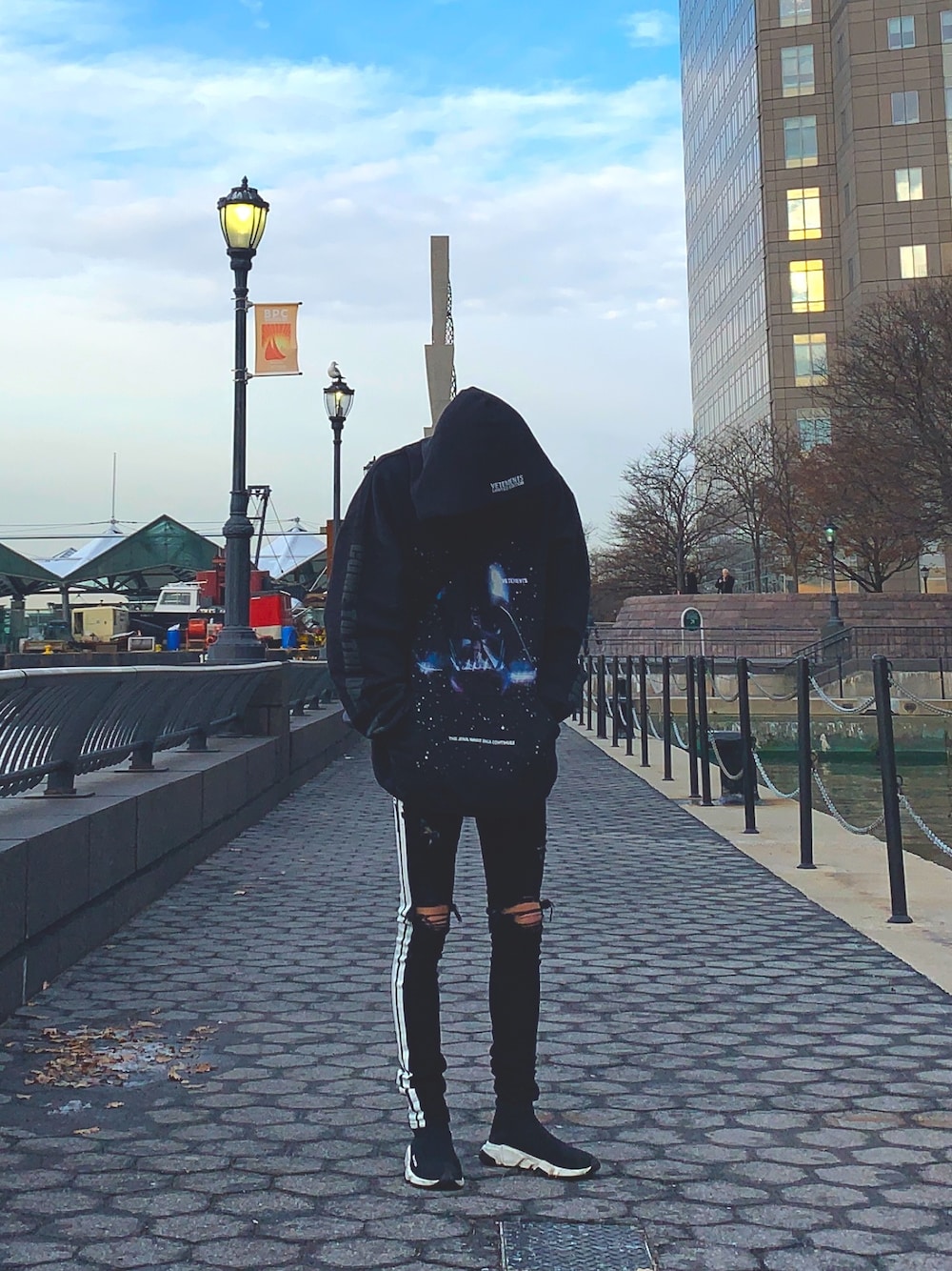 ブラック系のパーカー、ブラック系のデニムパンツ、ブラック系のスニーカーを着用したメンズの冬コーディネートの1枚目の写真