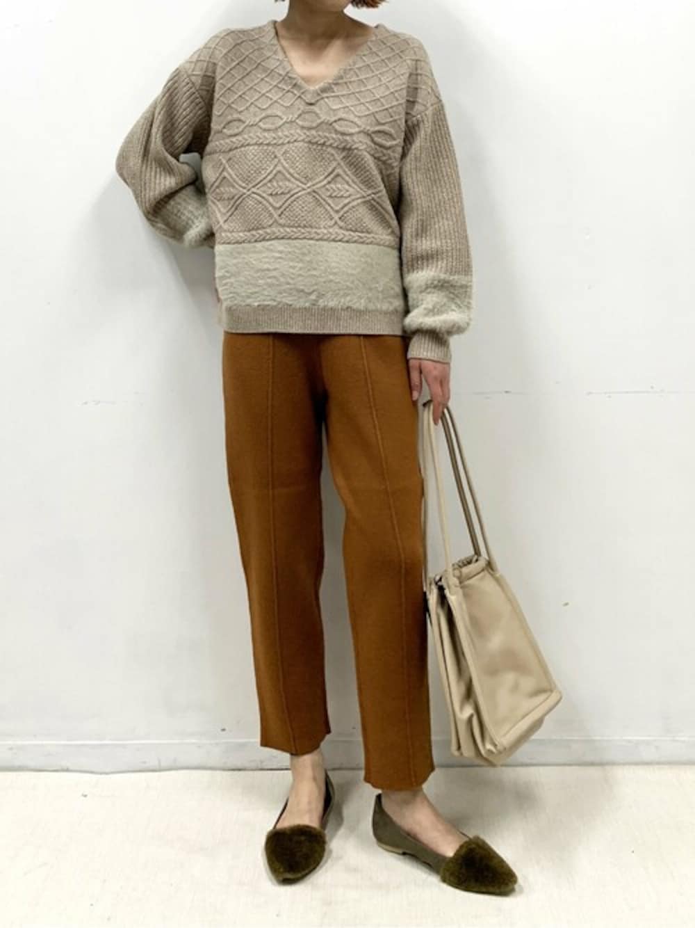 ベージュ系のニット/セーター、イエロー系のその他パンツを着用したレディースの冬コーディネートの1枚目の写真
