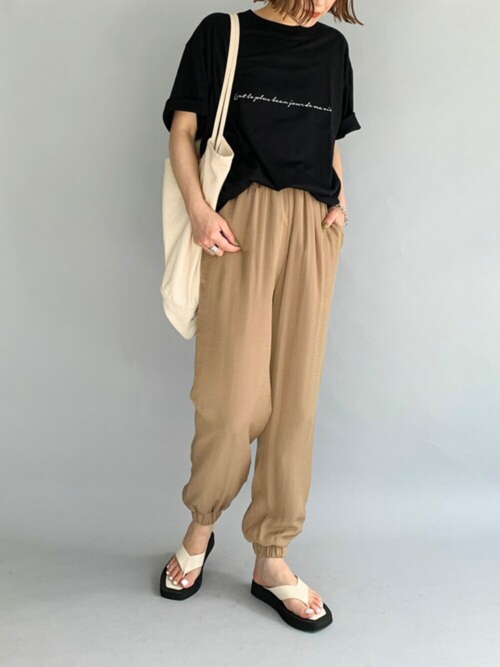 ブラック系のTシャツ/カットソー、イエロー系のその他パンツ、ブラック系のサンダルを着用したレディースの夏コーディネートの1枚目の写真