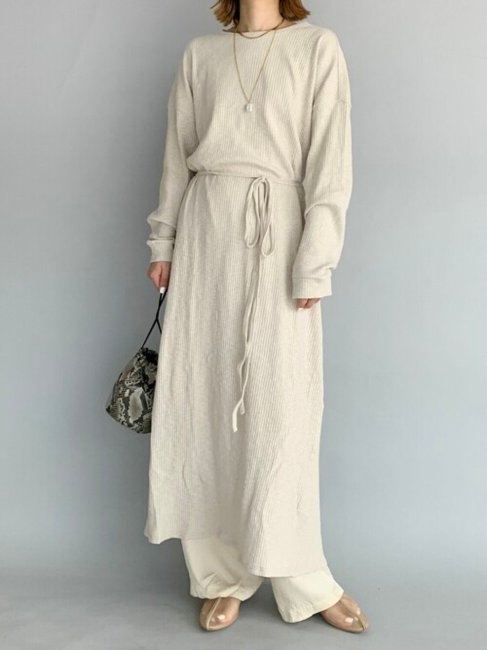 ベージュ系のTシャツ/カットソー、ベージュ系のパンプス、ブラック系のショルダーバッグを着用したレディースの夏コーディネートの1枚目の写真