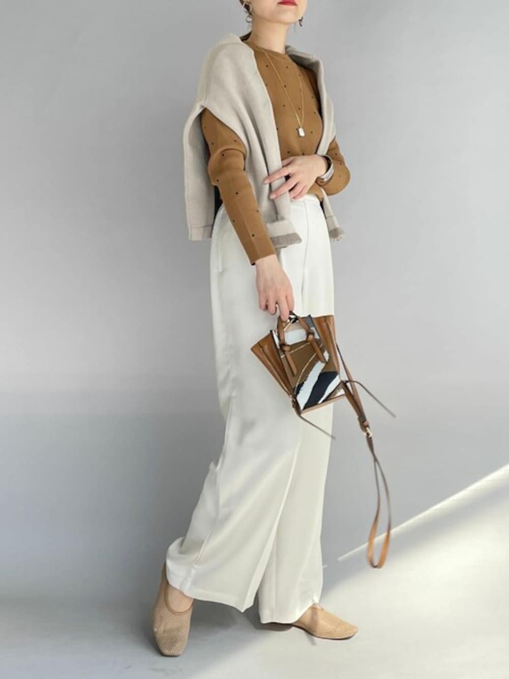 イエロー系のニット/セーター、ベージュ系のカーディガン/ボレロ、ホワイト系のその他パンツを着用したレディースの秋コーディネートの1枚目の写真