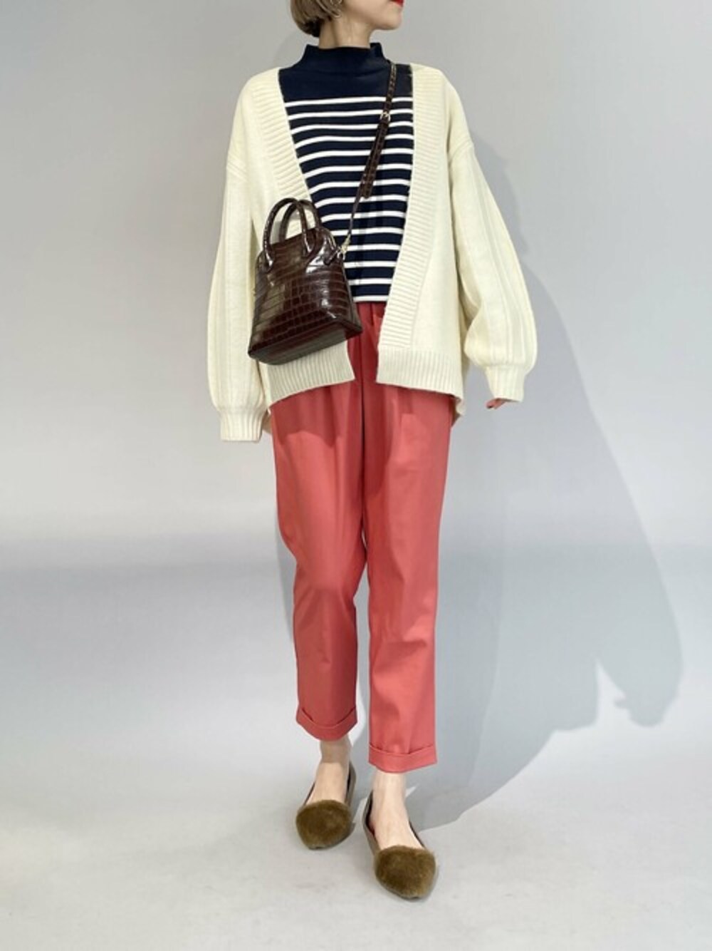 ホワイト系のカーディガン/ボレロ、ピンク系のその他パンツを着用したレディースの冬コーディネートの1枚目の写真