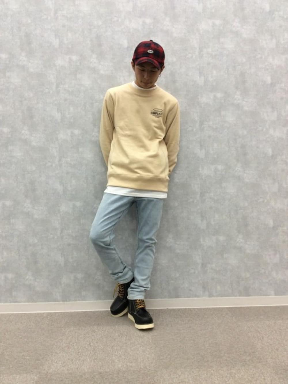 ベージュ系のスウェット、レッド系のキャップを着用したメンズの秋コーディネートの1枚目の写真