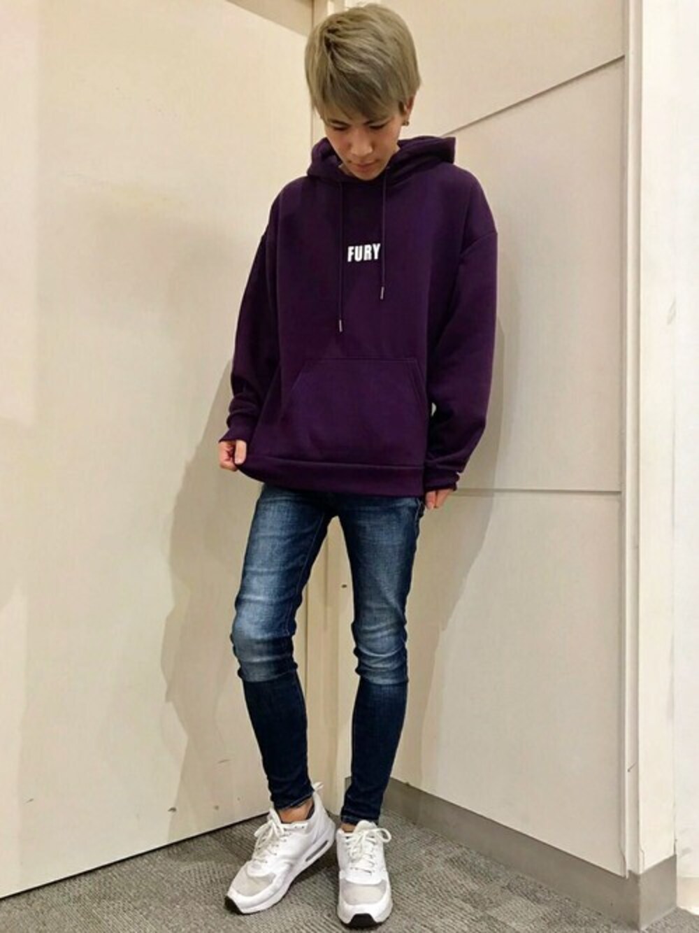パープル系のパーカー、ブルー系のデニムパンツを着用したメンズの冬コーディネートの1枚目の写真