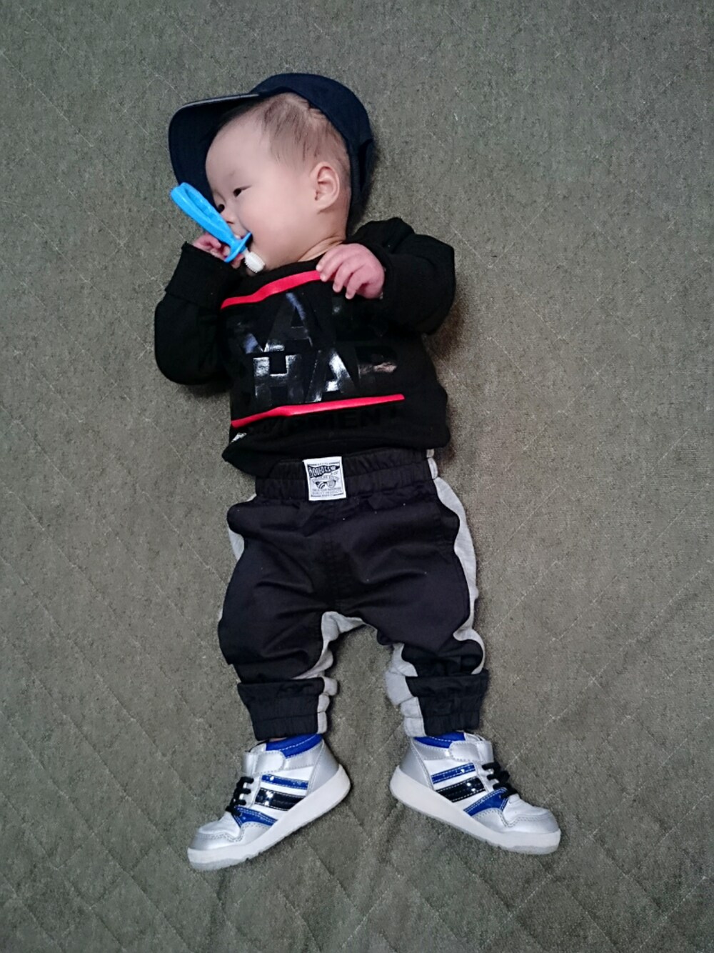 ブラック系のその他パンツ、ブラック系のスウェット、ブルー系のスニーカーを着用したキッズの冬コーディネートの1枚目の写真