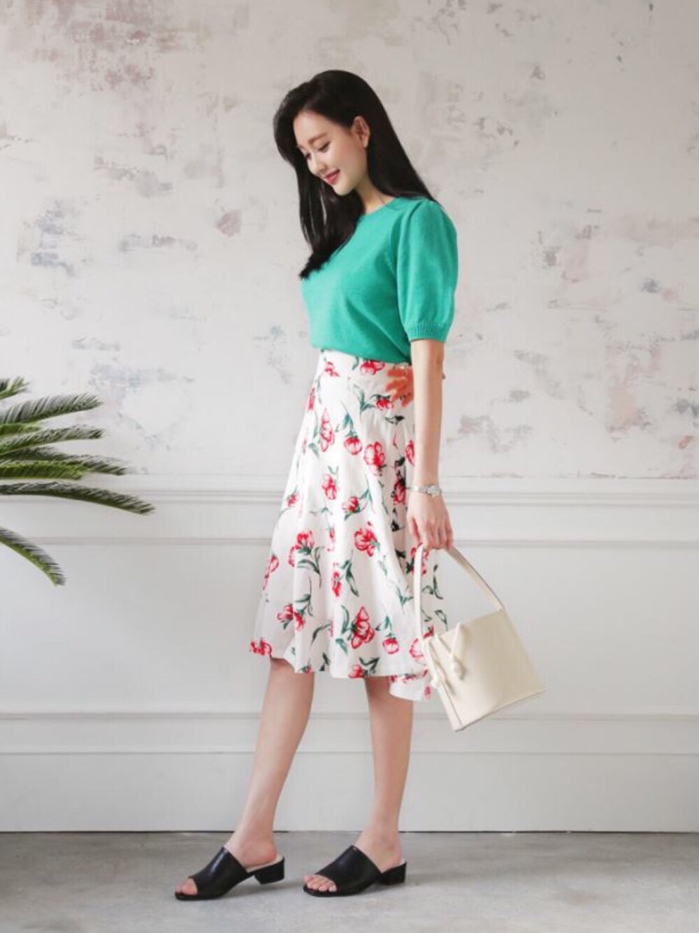 グリーン系のニット/セーター、ピンク系のスカートを着用したレディースの春コーディネートの1枚目の写真