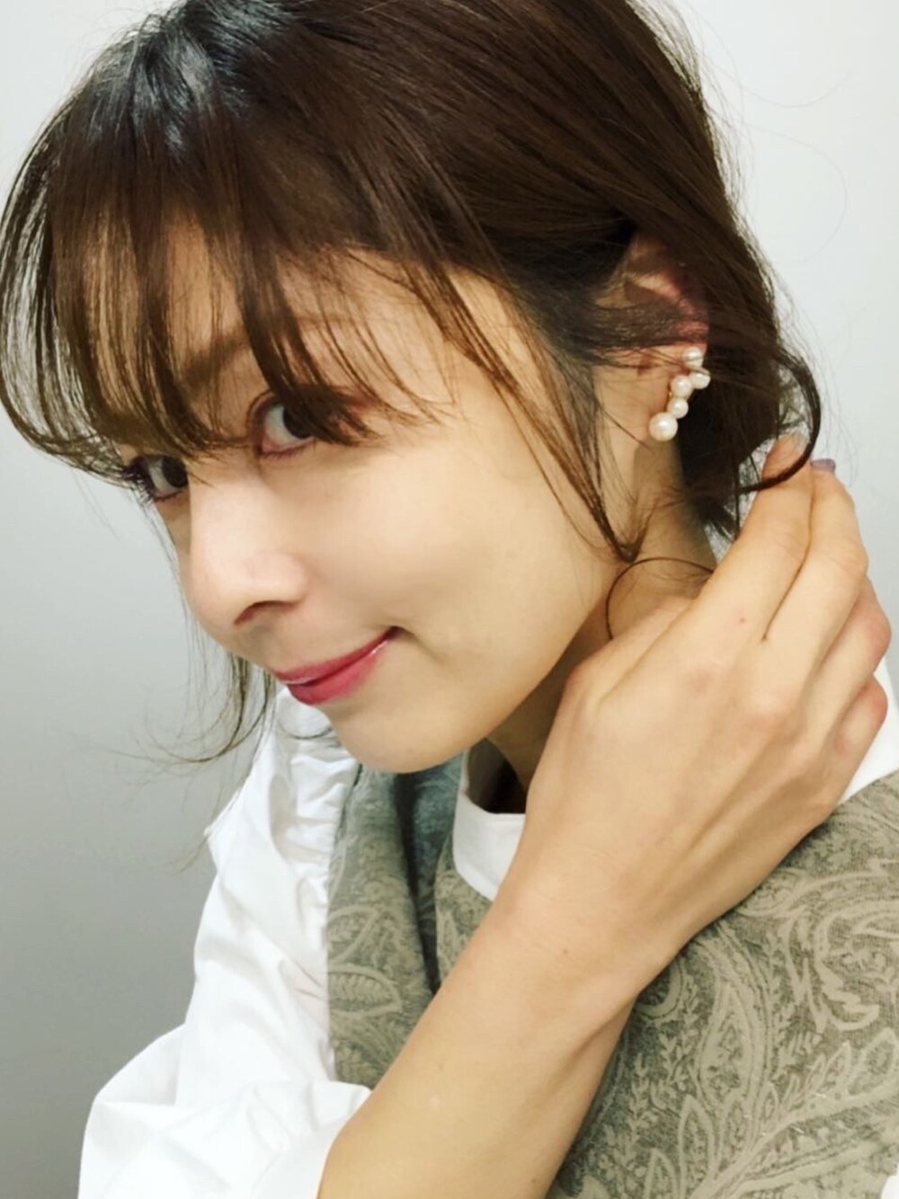 ゴールド系のイヤリングを着用したレディースの冬コーディネートの1枚目の写真