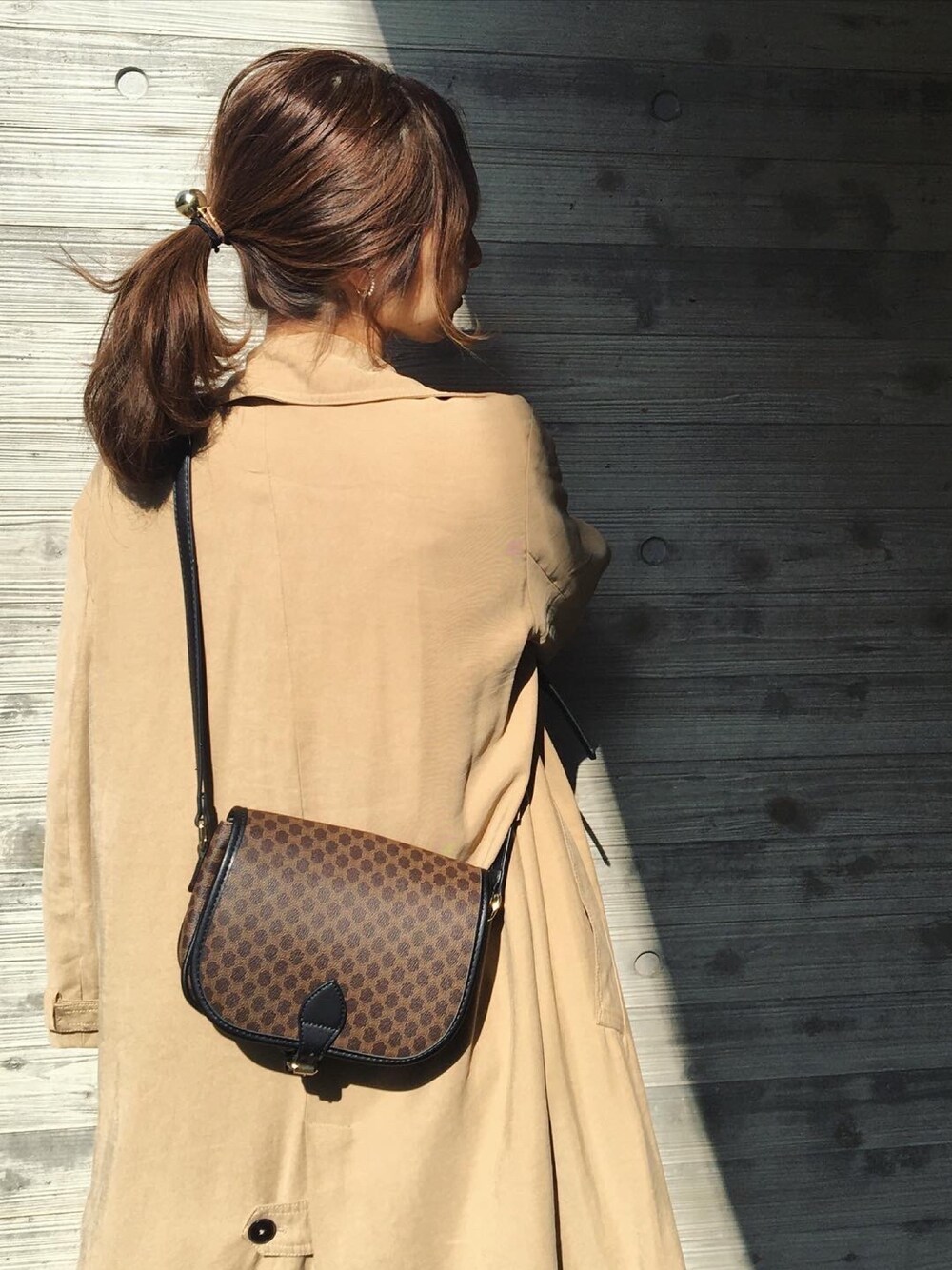 ブラウン系のバッグ、ゴールド系のヘアゴムを着用したレディースの冬コーディネートの1枚目の写真