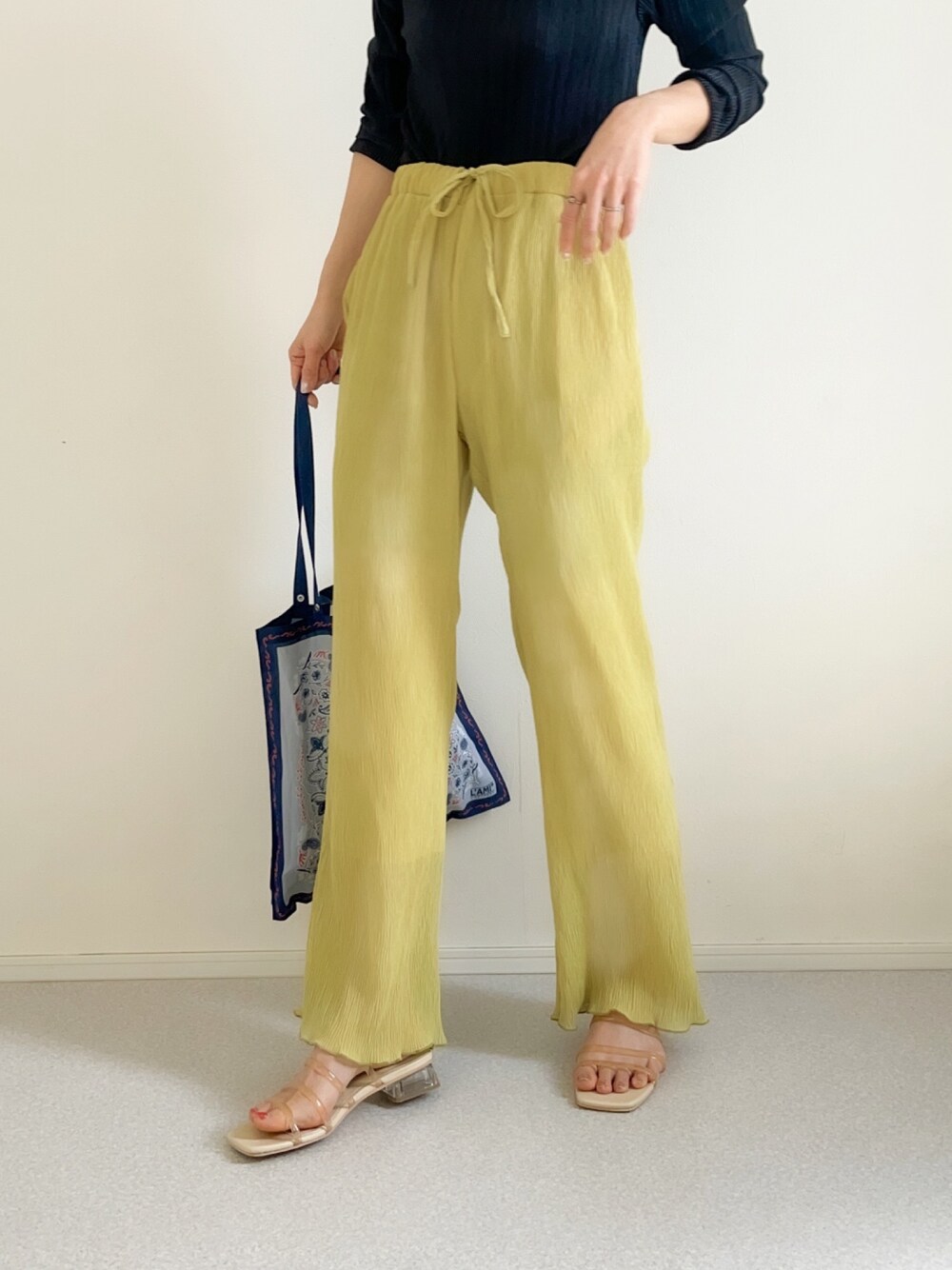 グリーン系のその他パンツ、ブルー系のエコバッグ/サブバッグ、ベージュ系のサンダルを着用したレディースの春コーディネートの1枚目の写真