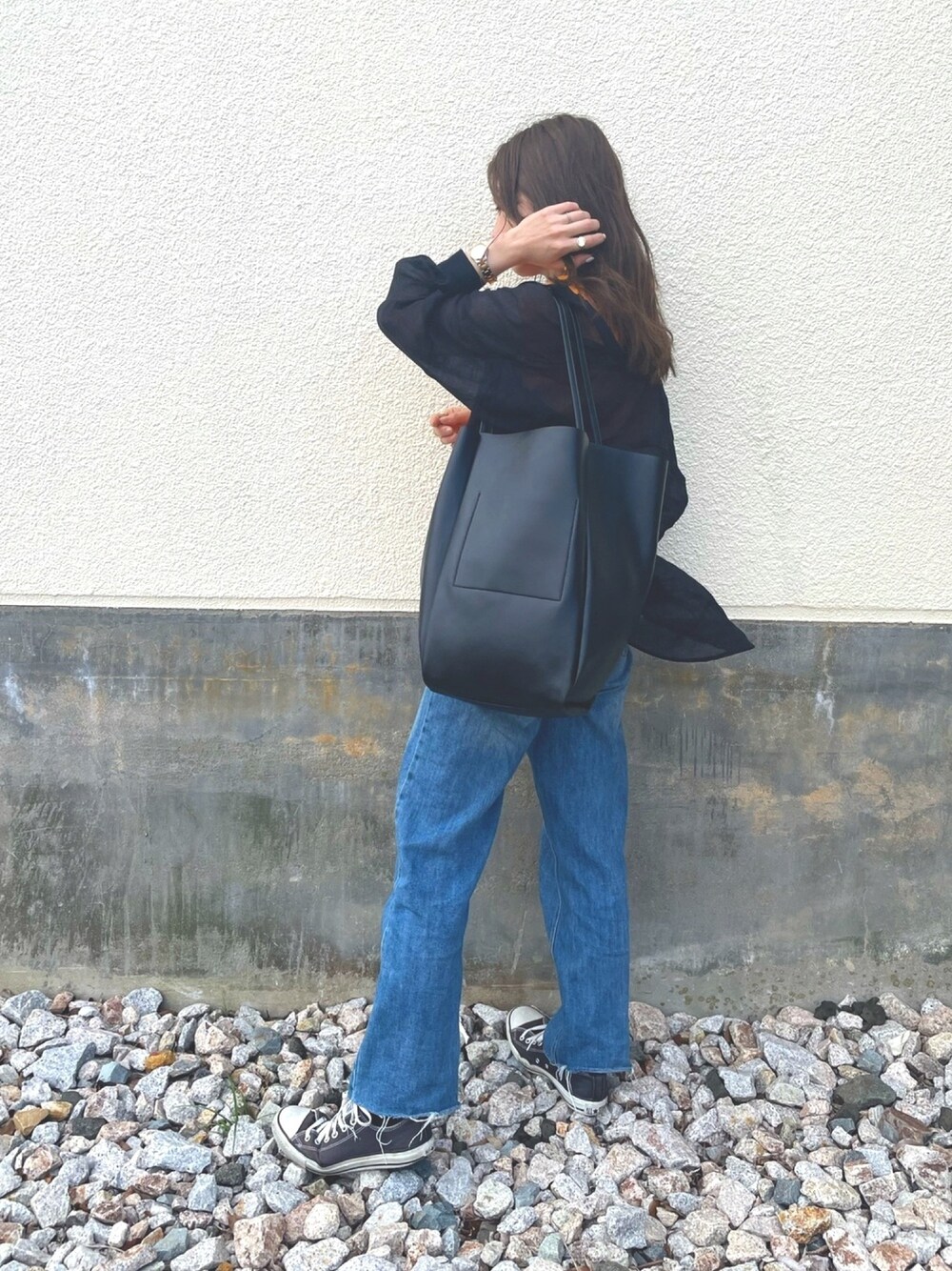 ブラック系のトートバッグを着用したレディースの春コーディネートの1枚目の写真