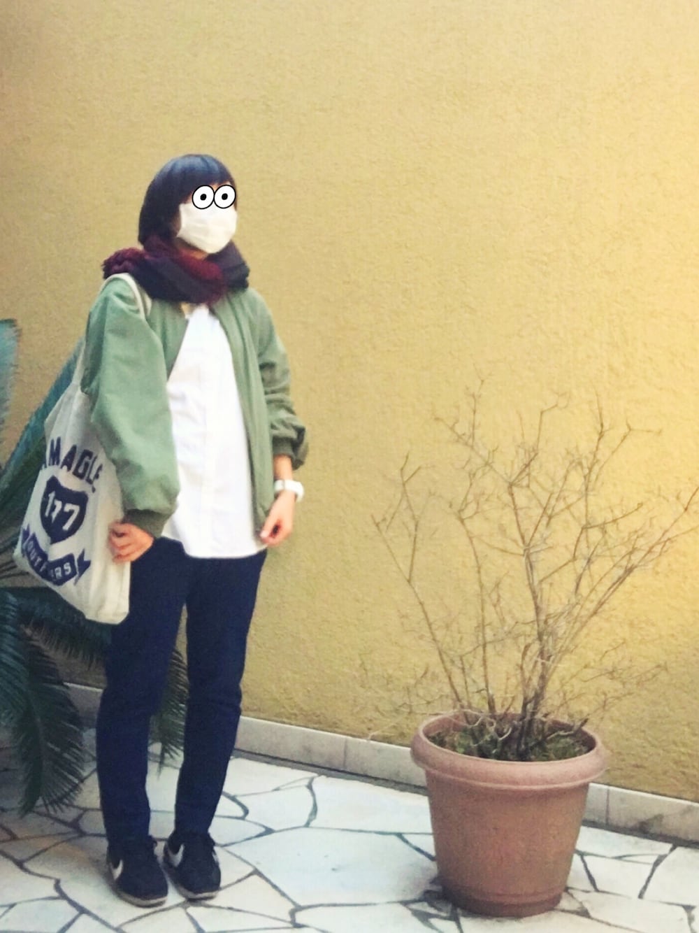 グリーン系のブルゾン、ホワイト系のシャツ/ブラウス、グレー系のトートバッグを着用したレディースの冬コーディネートの1枚目の写真