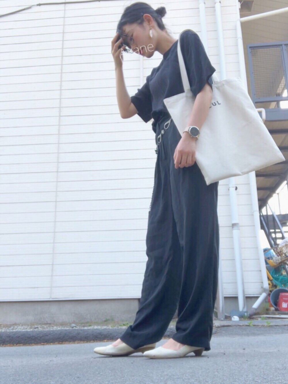 ブラック系のシャツ/ブラウス、ブラック系のパンツ、ホワイト系のトートバッグを着用したレディースの春コーディネートの1枚目の写真