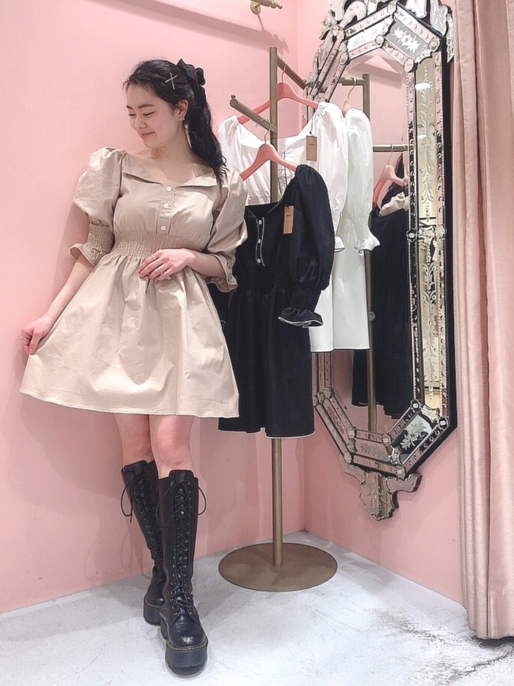 ベージュ系のワンピース、ブラック系のブーツ、ブラック系のシュシュを着用したレディースの春コーディネートの1枚目の写真