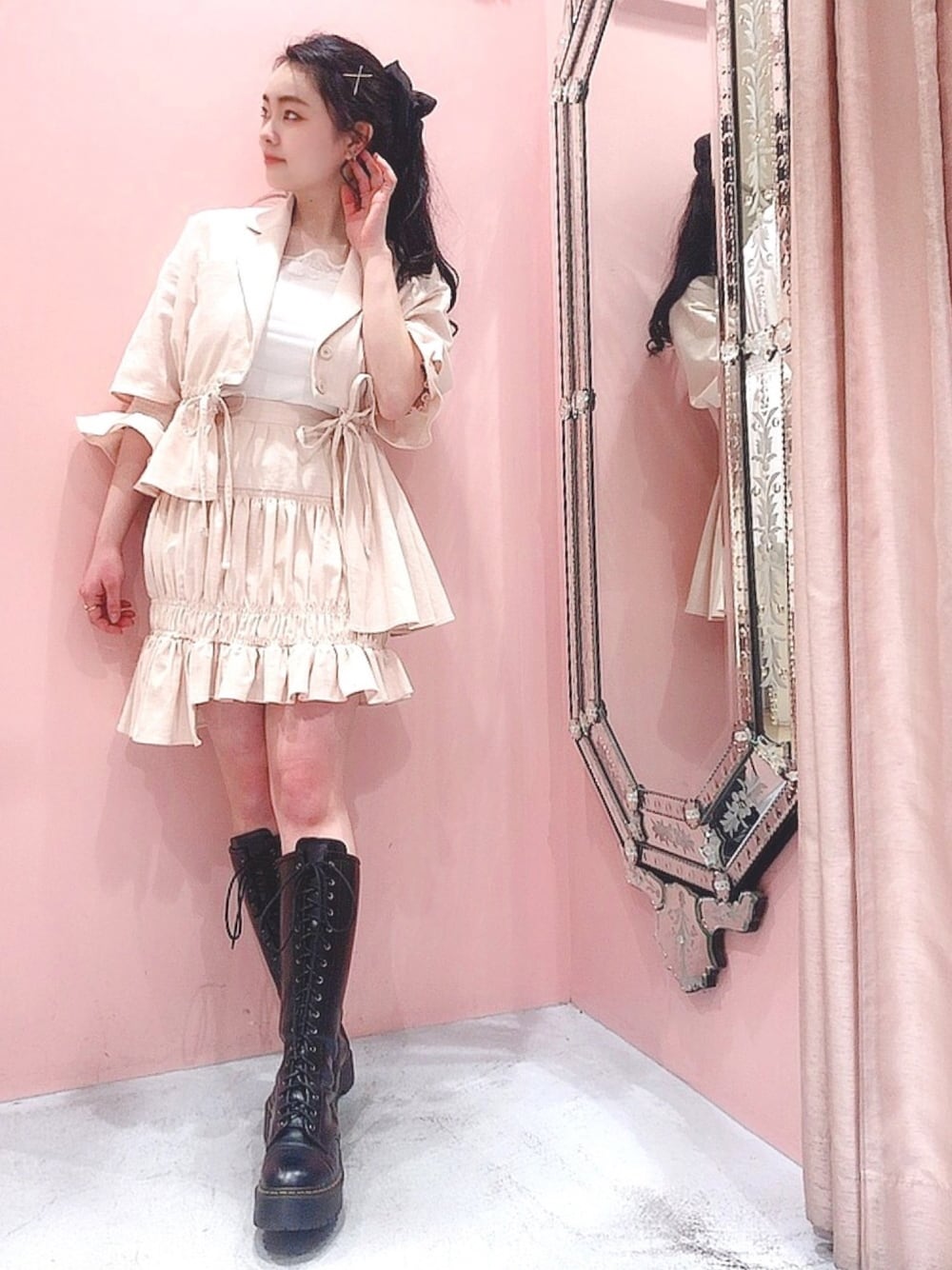 ベージュ系のスカート、ブラック系のブーツ、ベージュ系のトップスを着用したレディースの春コーディネートの1枚目の写真