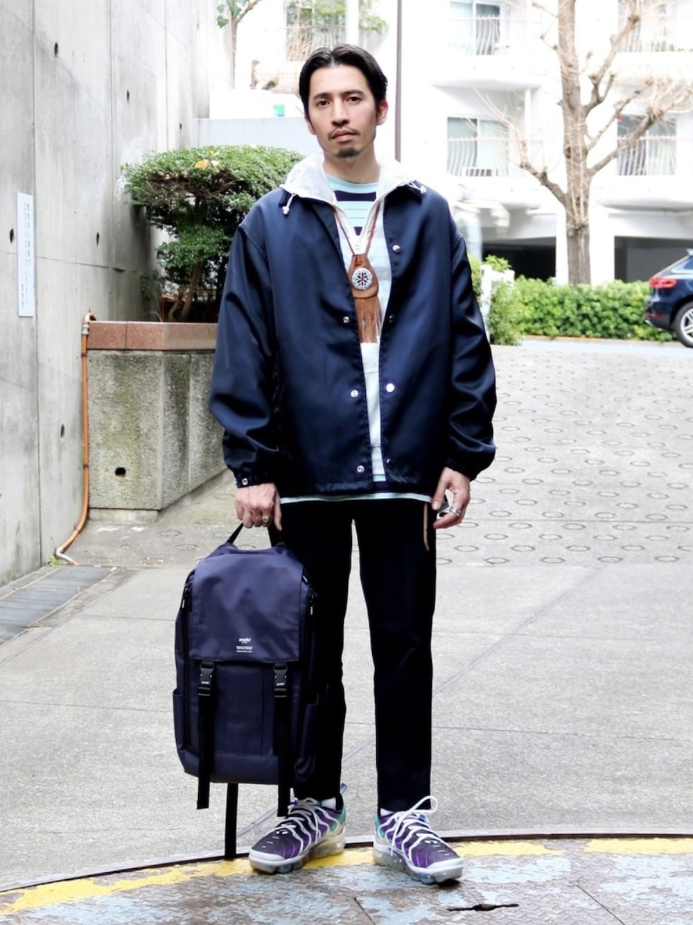 ブルー系のナイロンジャケット、ホワイト系のジャケット/アウター、ブルー系のスラックスを着用したメンズの冬コーディネートの1枚目の写真