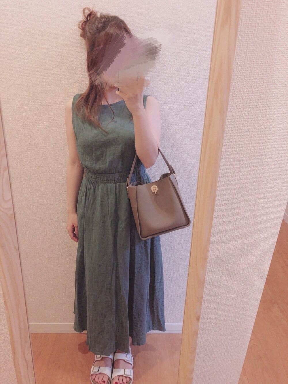 ブラウン系のハンドバッグ、グリーン系のワンピースを着用したレディースの夏コーディネートの1枚目の写真