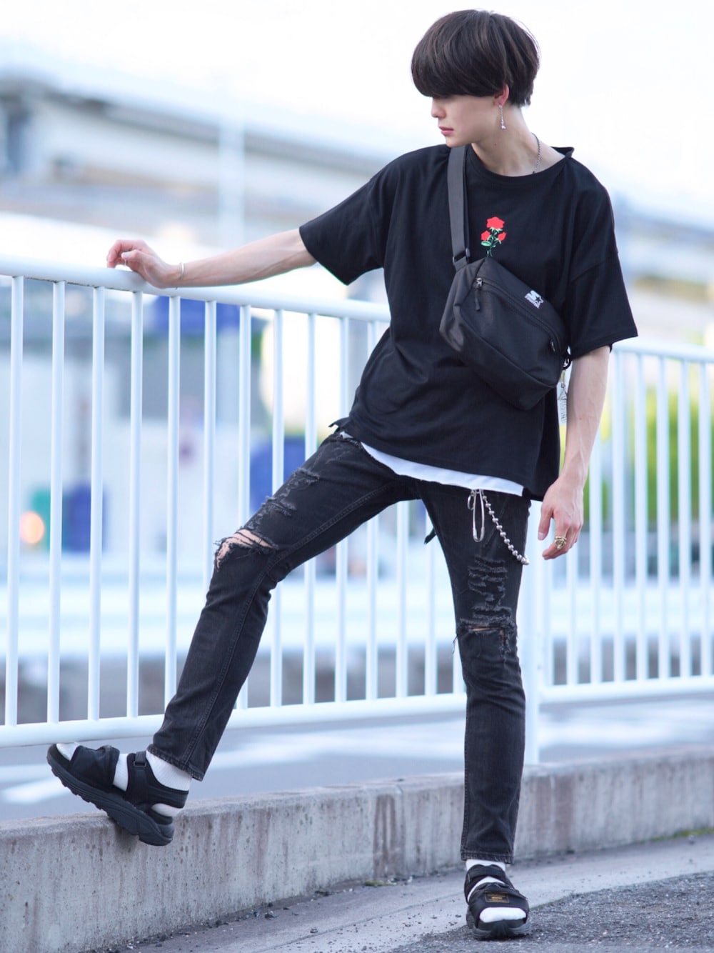 ブラック系のショルダーバッグ、ホワイト系のタンクトップ、ブラック系のデニムパンツを着用したメンズの夏コーディネートの1枚目の写真