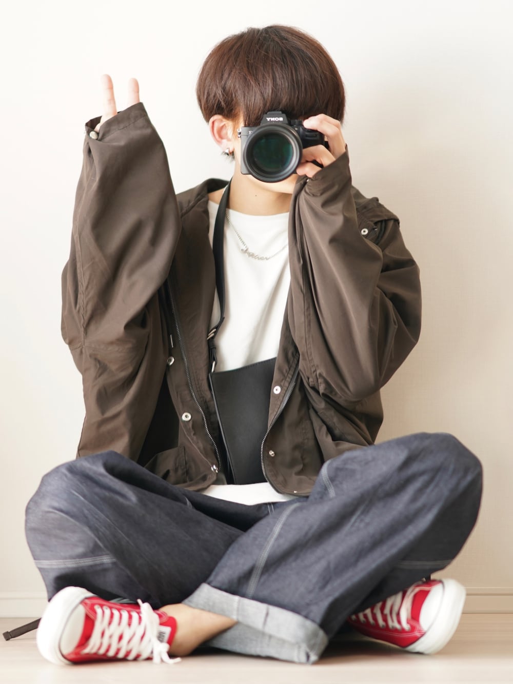 グレー系のマウンテンパーカー、ホワイト系のTシャツ/カットソー、ブラック系のショルダーバッグを着用したメンズの春コーディネートの1枚目の写真