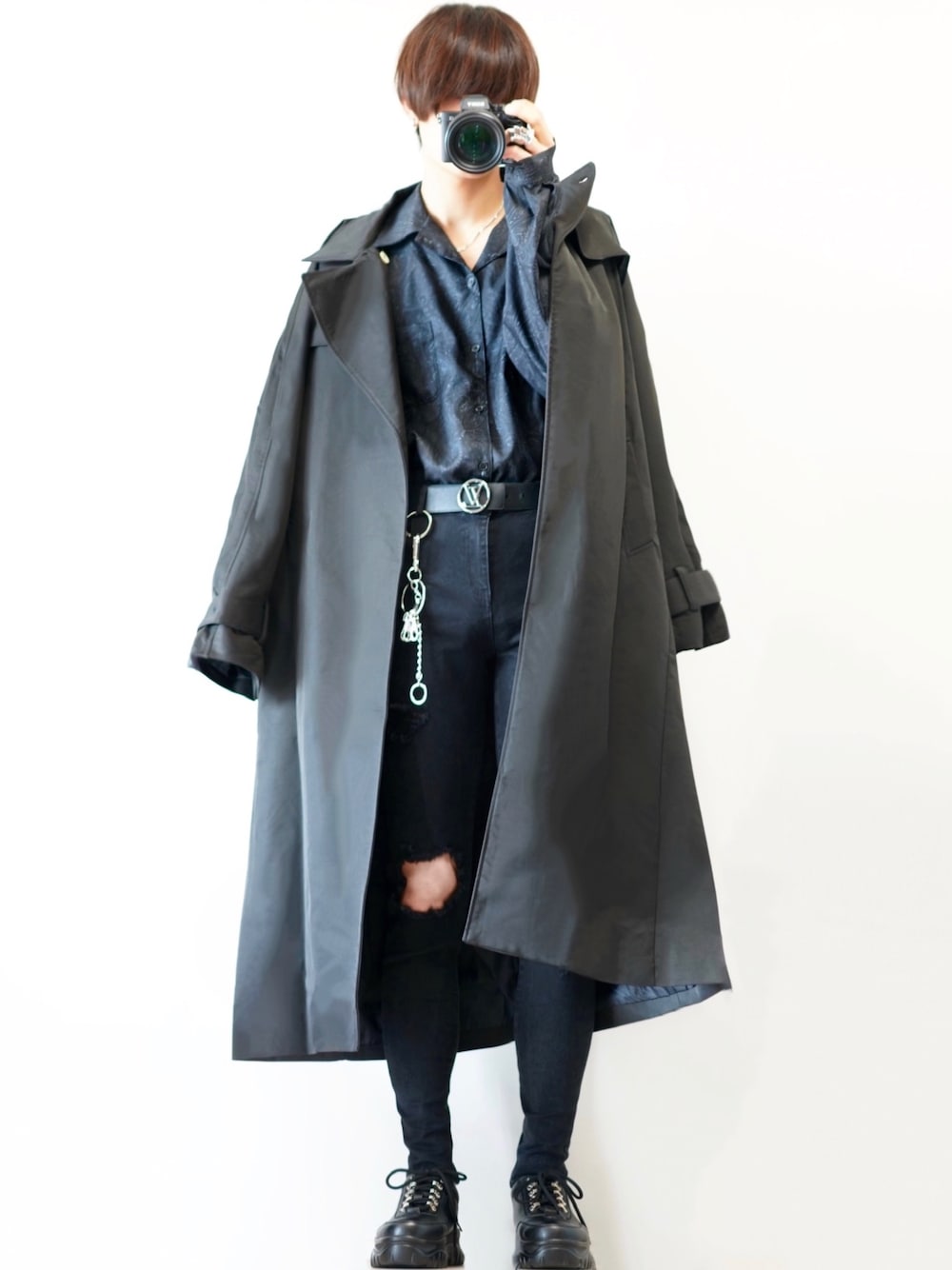 ブラック系のトレンチコート、ブラック系のデニムパンツ、ブラック系のスニーカーを着用したメンズの秋コーディネートの1枚目の写真