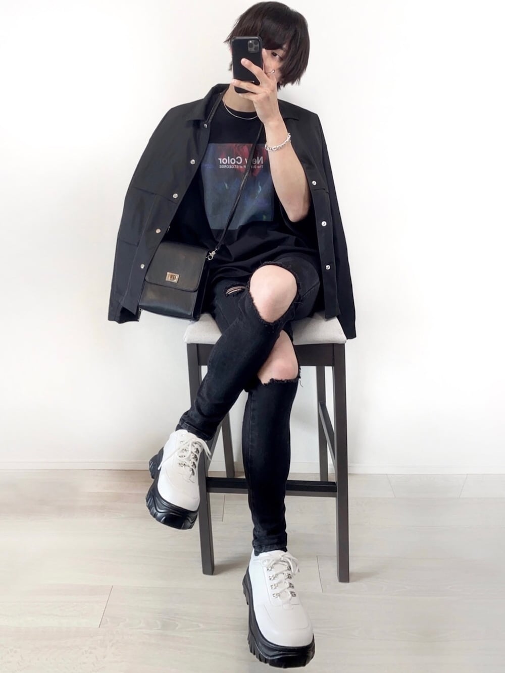ブラック系のデニムパンツ、ブラック系のデニムジャケット、ホワイト系のスニーカーを着用したメンズの春コーディネートの1枚目の写真